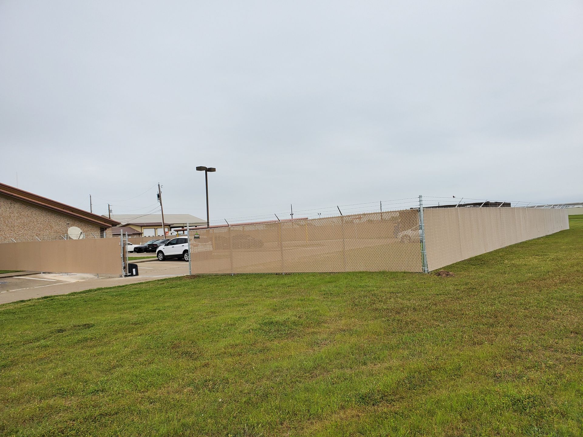 A large fence is sitting in the middle of a grassy field.