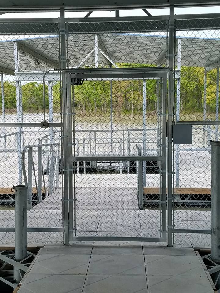 A dock with a chain link fence and a gate leading to it.