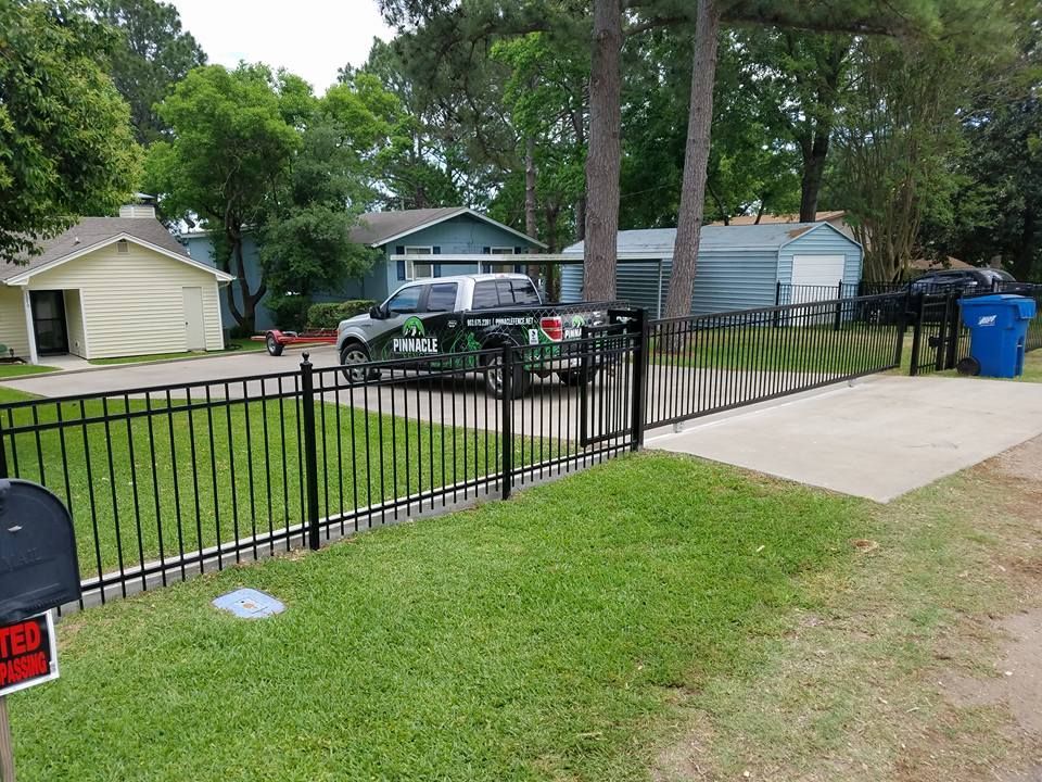 A truck is parked in front of a fence next to a mailbox.