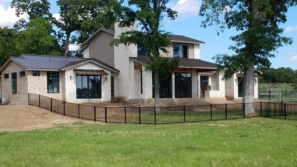 A large white house with a black fence around it