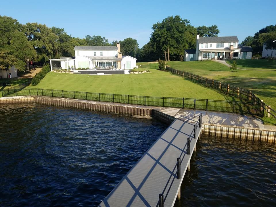 A large house sits on the shore of a lake