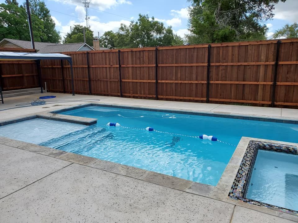 A large swimming pool with a wooden fence surrounding it