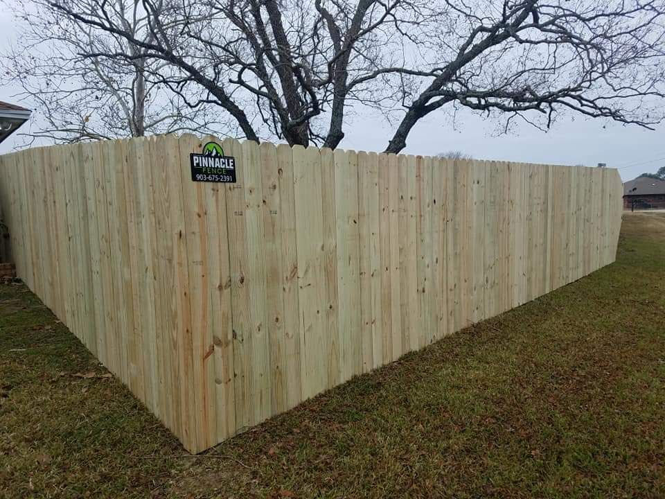 A wooden fence is sitting in the middle of a grassy field.