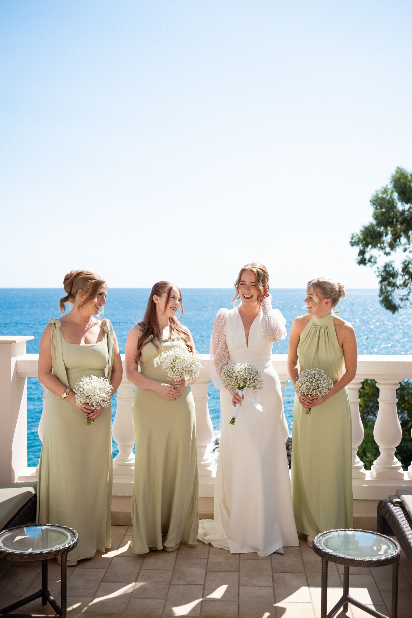 Bride and bridesmaids before a wedding in front of the sea at The Tiara Miramar Beach Resort Hotel wedding venue.