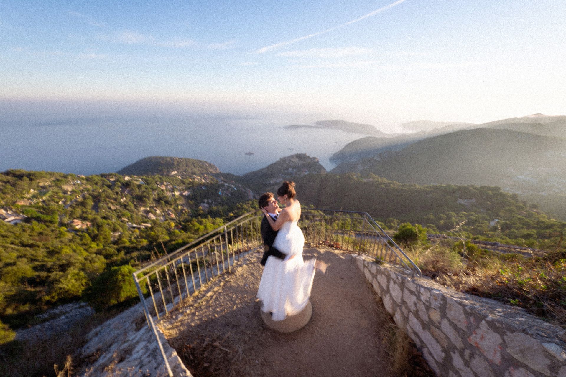A couple eloping with a spectacular view of the sea behind them on the French Riviera.