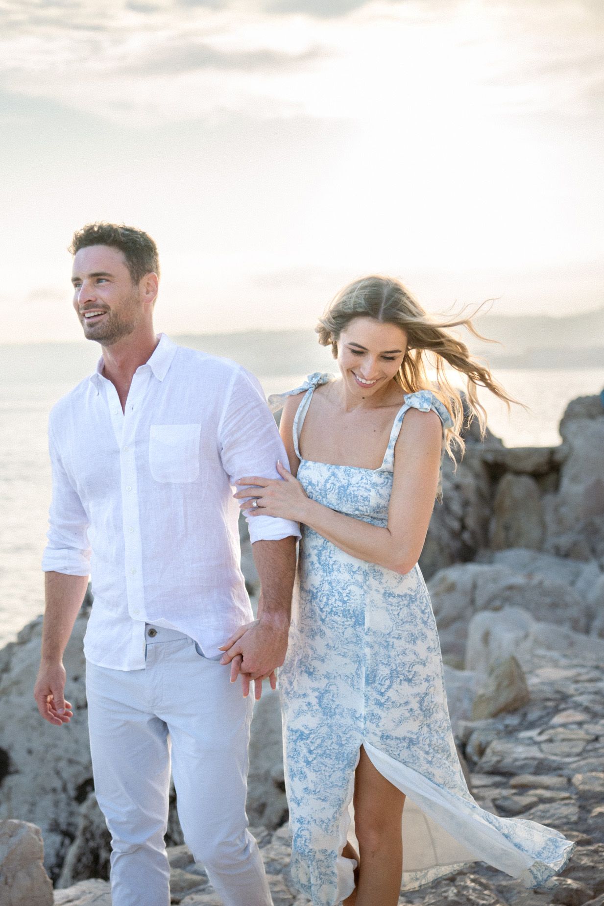 A couple walking at sunset laughing during an engagement photoshoot in Nice.