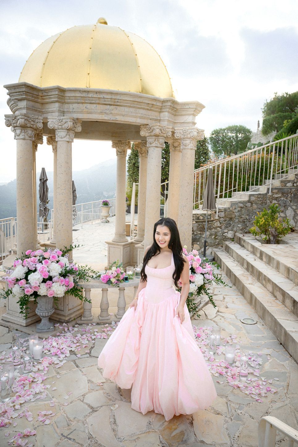 Portrait of a young lady with matching pink flowers and dress after getting engaged at the Temple of Love.
