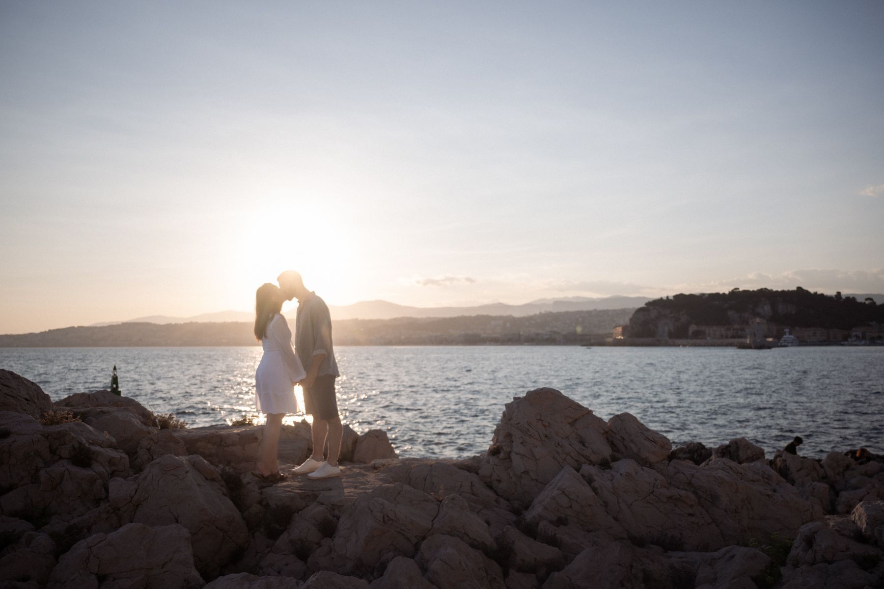 Silhouettes of a couple kissing with Nice, France, in the background.