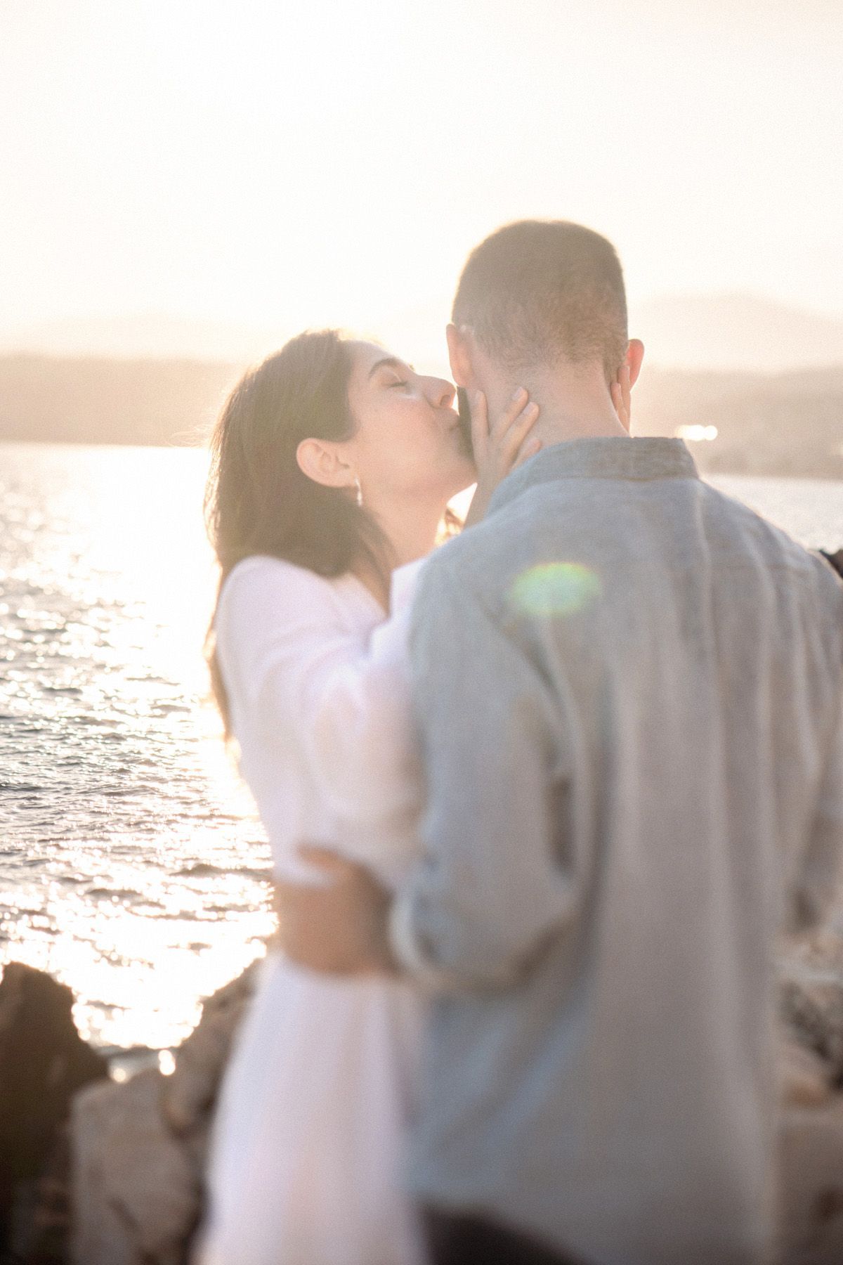 A couple kissing during a sunset photoshoot in Nice, France. Image taken with a Lensbaby 85mm Edge lens.