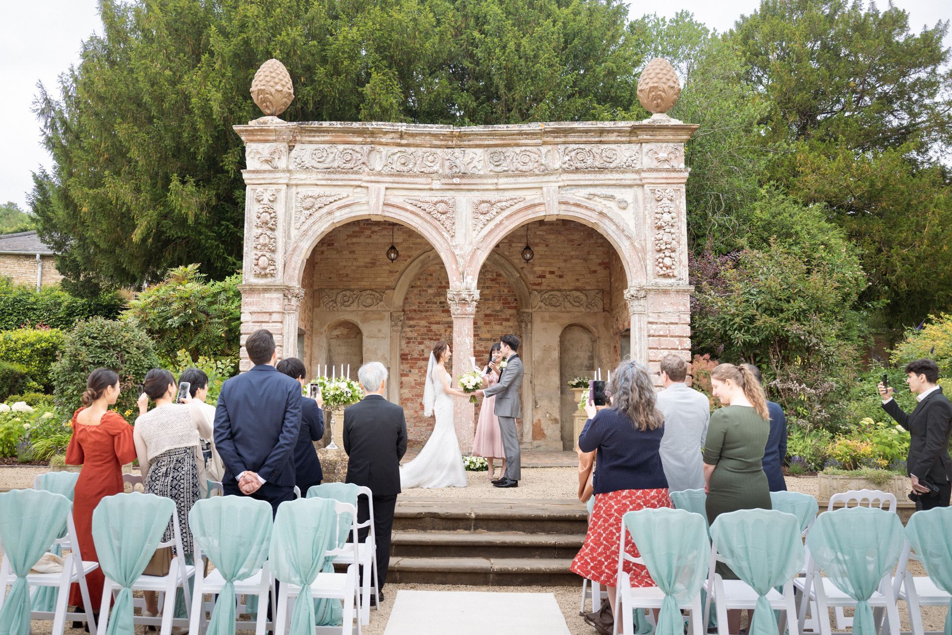 A wide angle shot of an outdoor ceremony at Ettington Park luxury wedding venue in Warwickshire