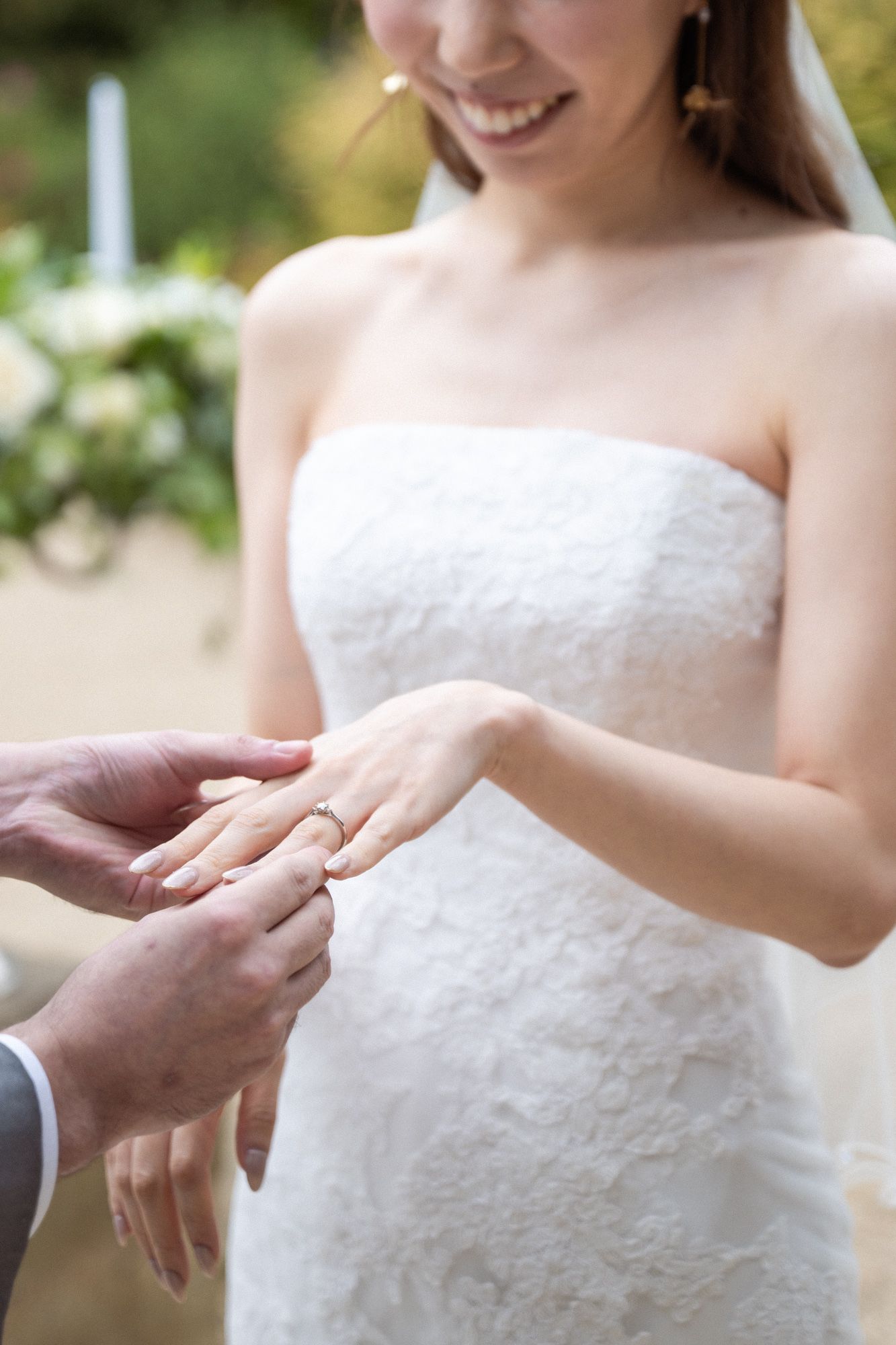 Wedding rings are exchanged during an outdoor wedding ceremony.