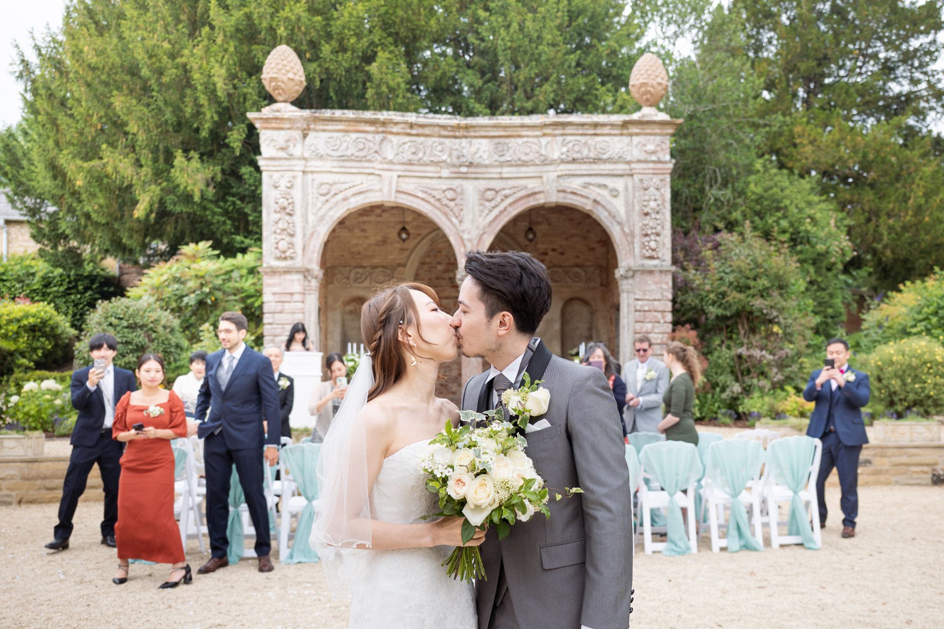 Confetti rains down on newly weds at an outdoor wedding ceremony at Ettington Park.