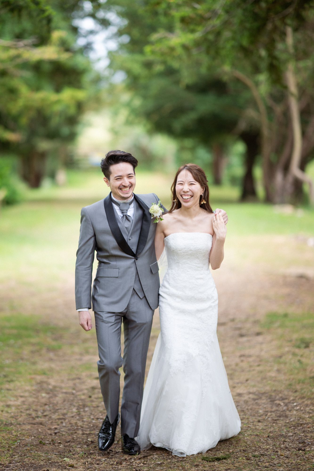Newlyweds laugh and smile during a relaxed, natural photoshoot at Ettington Park