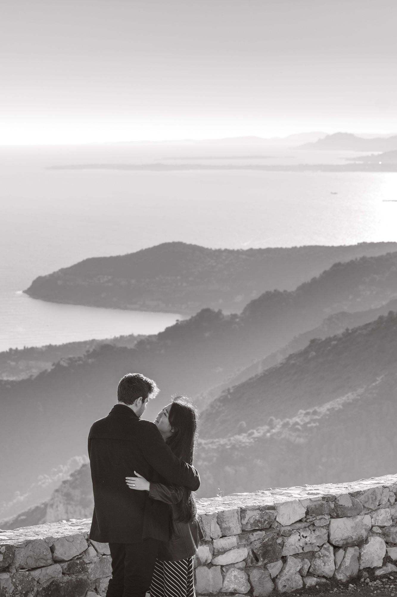 A couple embrace after a surprise proposal on the French Riviera.
