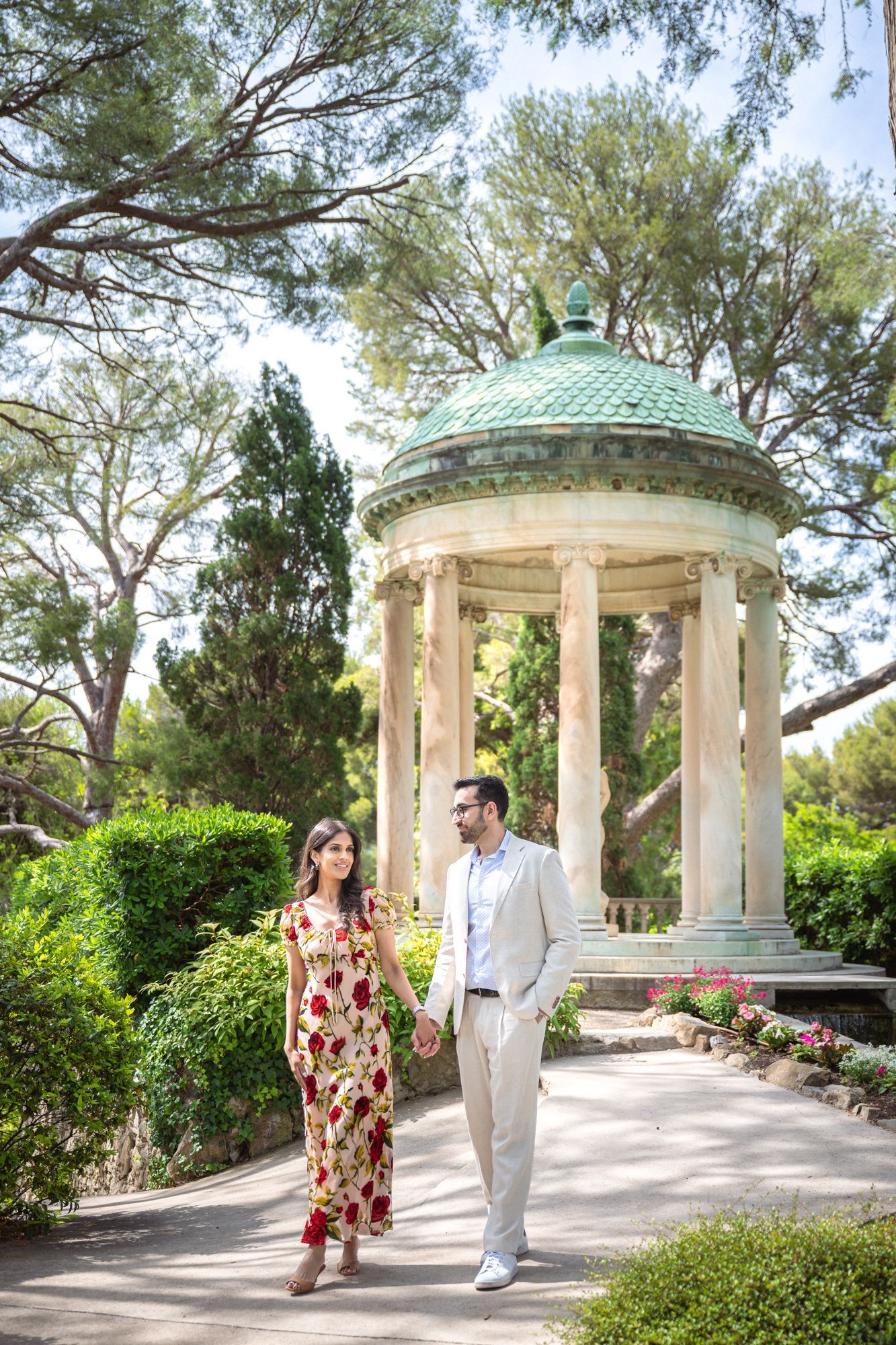 A couple walking past the Rotunda at Villa Ephrussi de Rothschild during an engagement photoshoot.