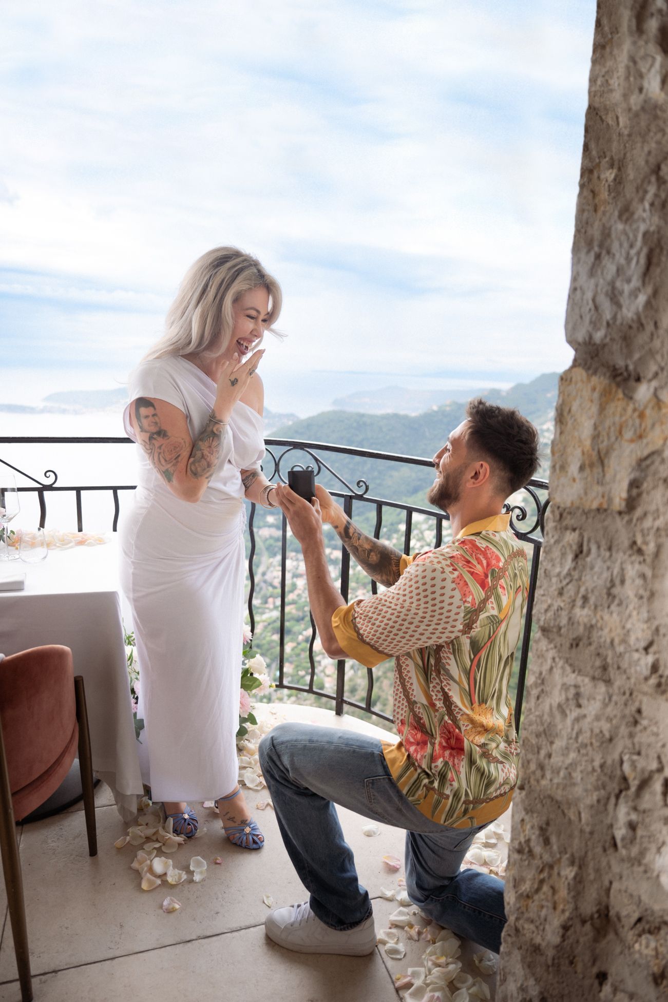 A man on his knees as he proposes on the balcony of Chateau Eza in Eze, French Riviera