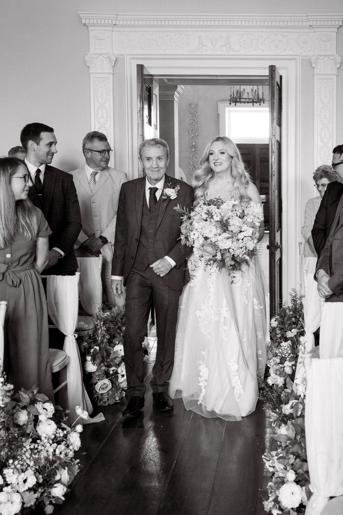 The bride walks down the aisle with her father during the wedding ceremony.