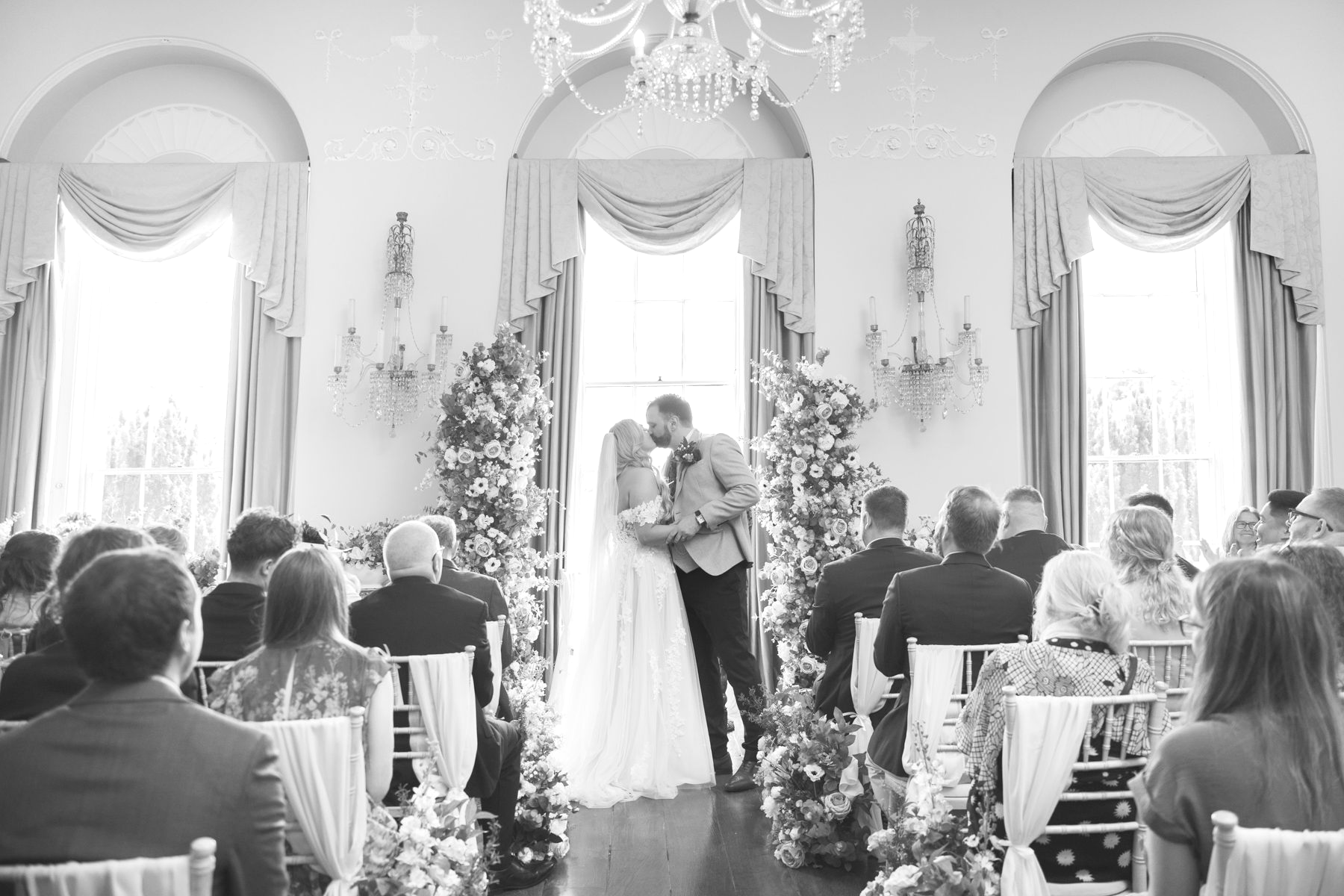 The first kiss during an indoor wedding ceremony at Kelmarsh Hall.