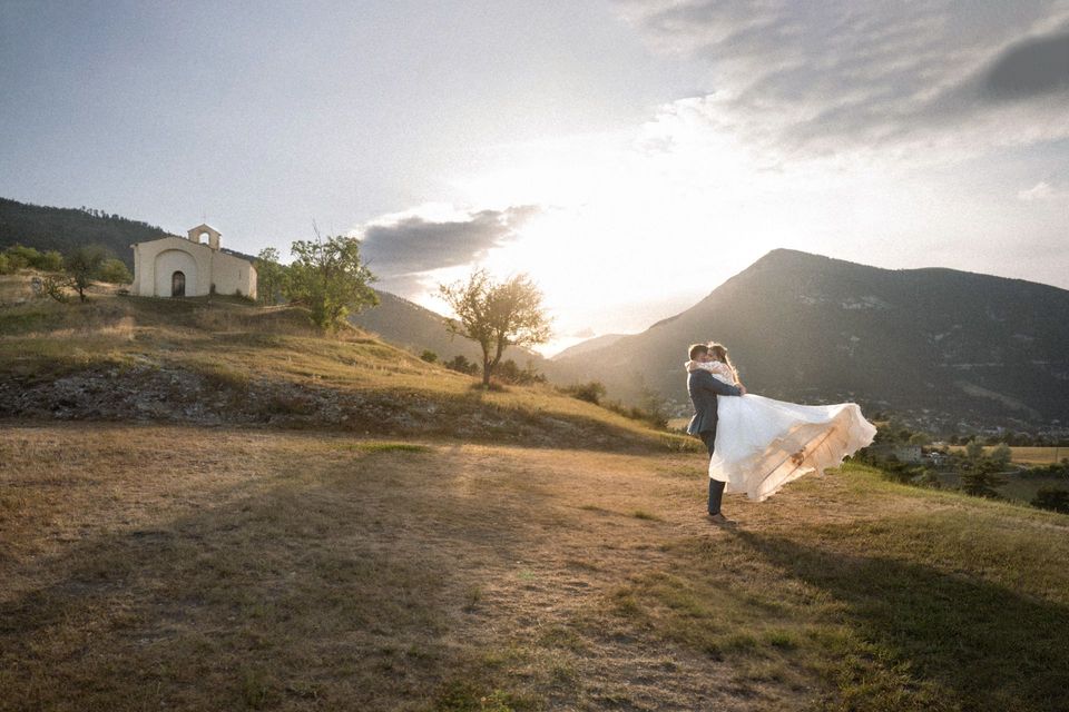 A groom spins his bride around during a photoshoot at sunset in the south of France.