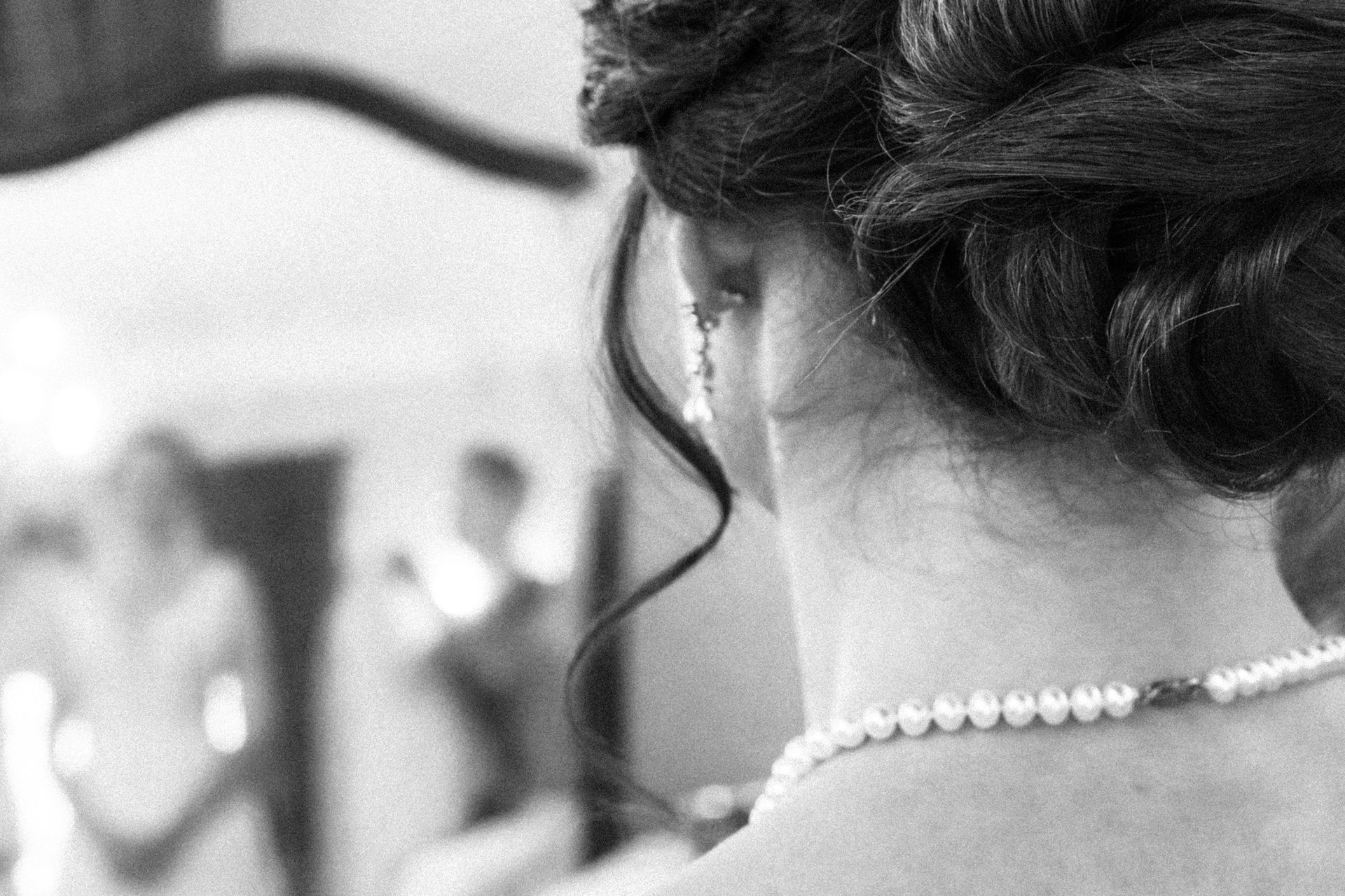 Les boucles d'oreilles de la mariée reposent sous ses cheveux le jour de son mariage.