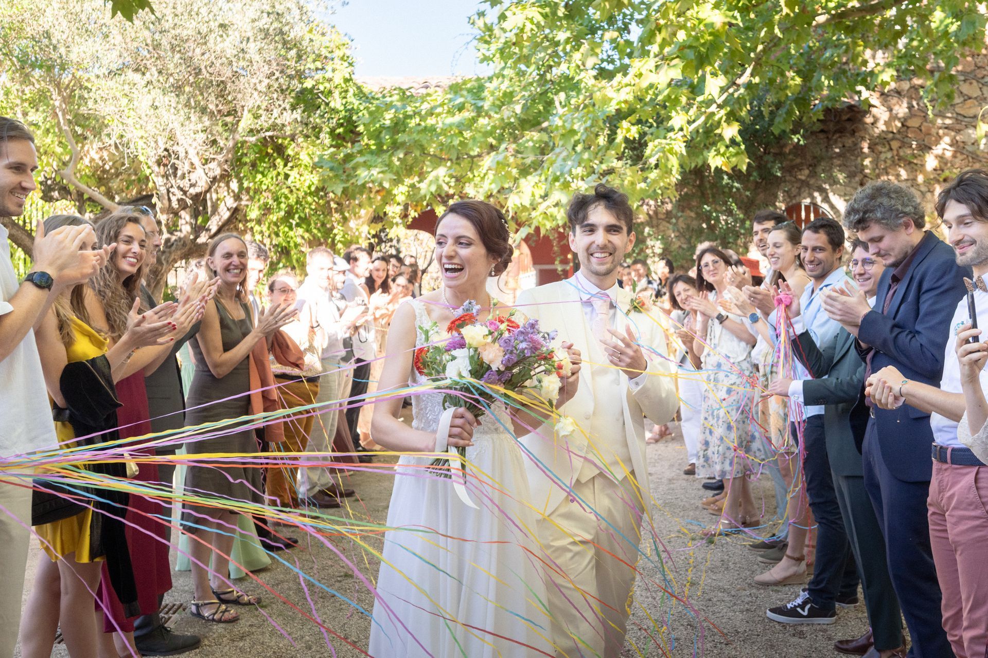 Le couple traverse des banderoles colorées au lieu de confettis au Château Font du Broc.