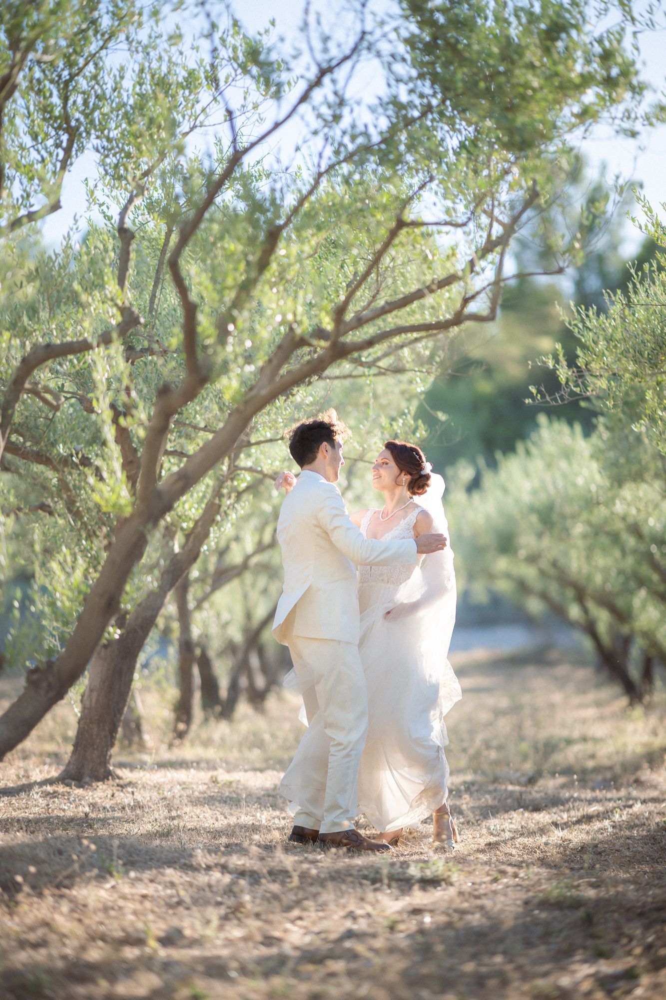 Un couple danse lors d'une séance photo naturelle, spontanée et improvisée le jour de leur mariage, dans une oliveraie provençale.