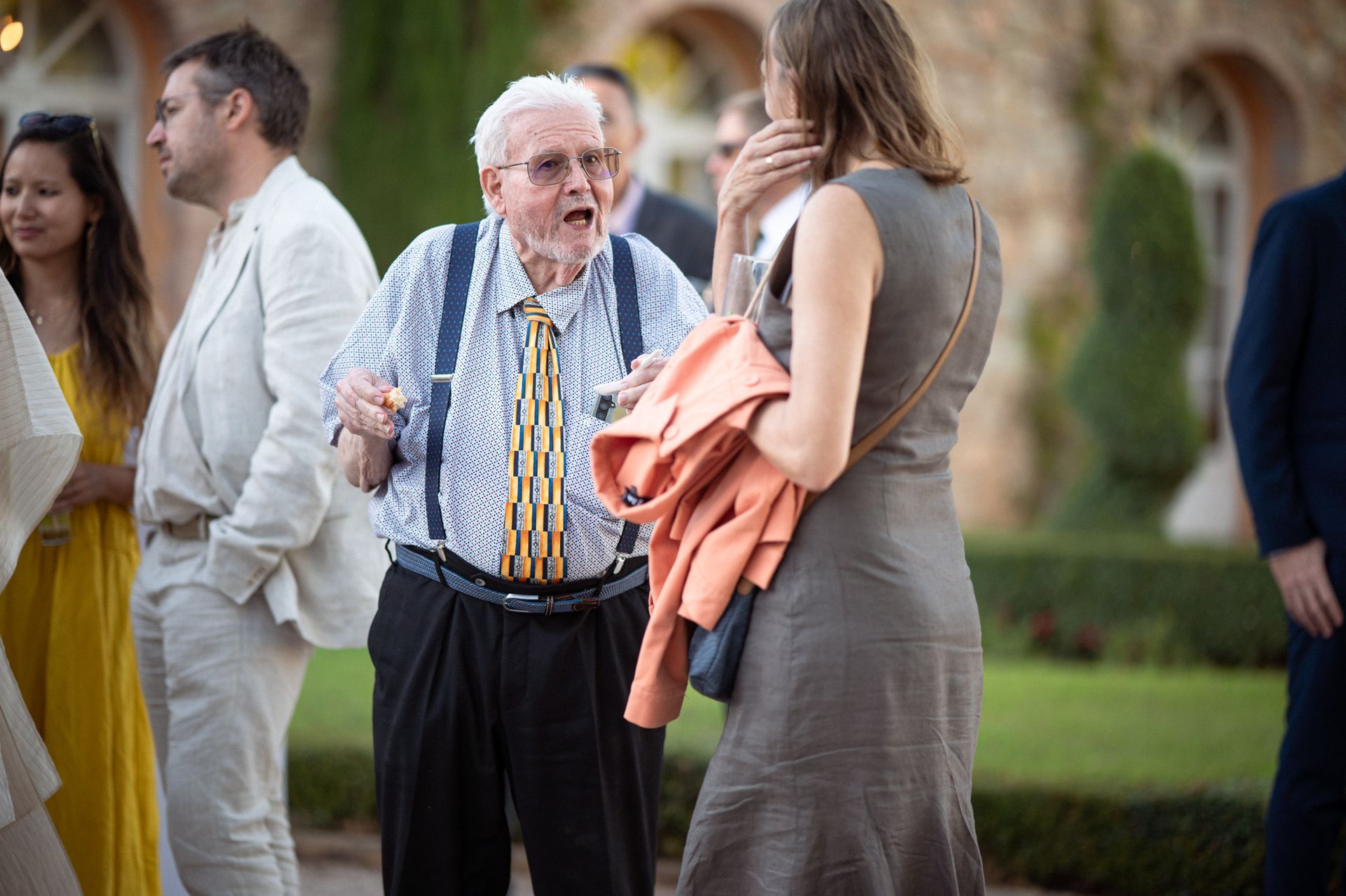 Photo de mariage prise sur le vif, représentant des invités discutant entre eux, dans un style reportage, au Château Font du Broc.