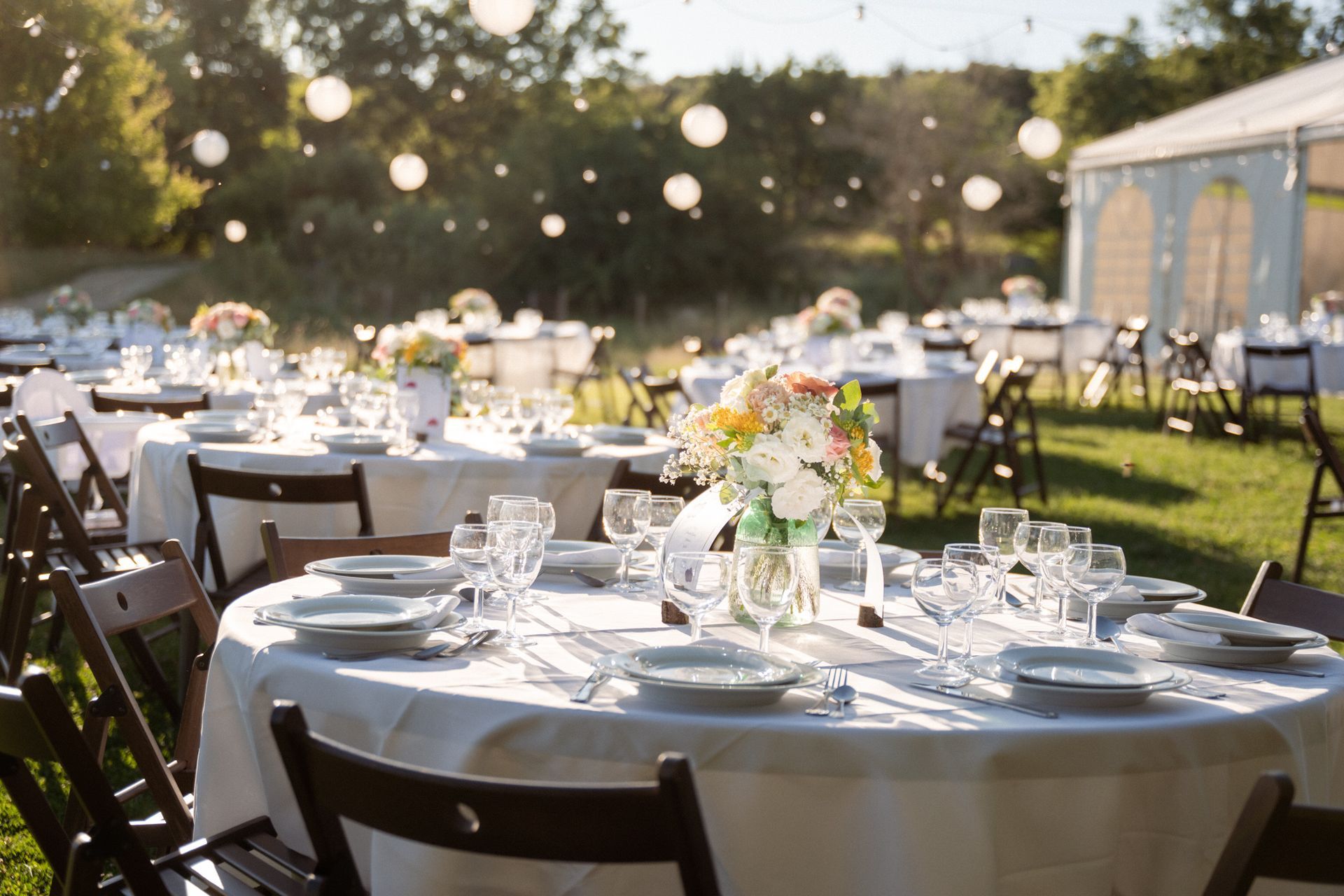 Tables de mariage habillées lors d'un van d'honneur en plein air au Domaine de Courmettes