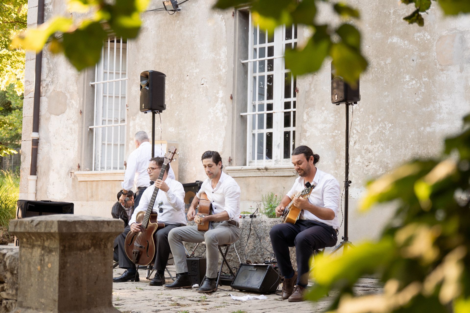 un concert de trois musiciens devant le Domaine des Courmettes pendant le Vin d'Honneur