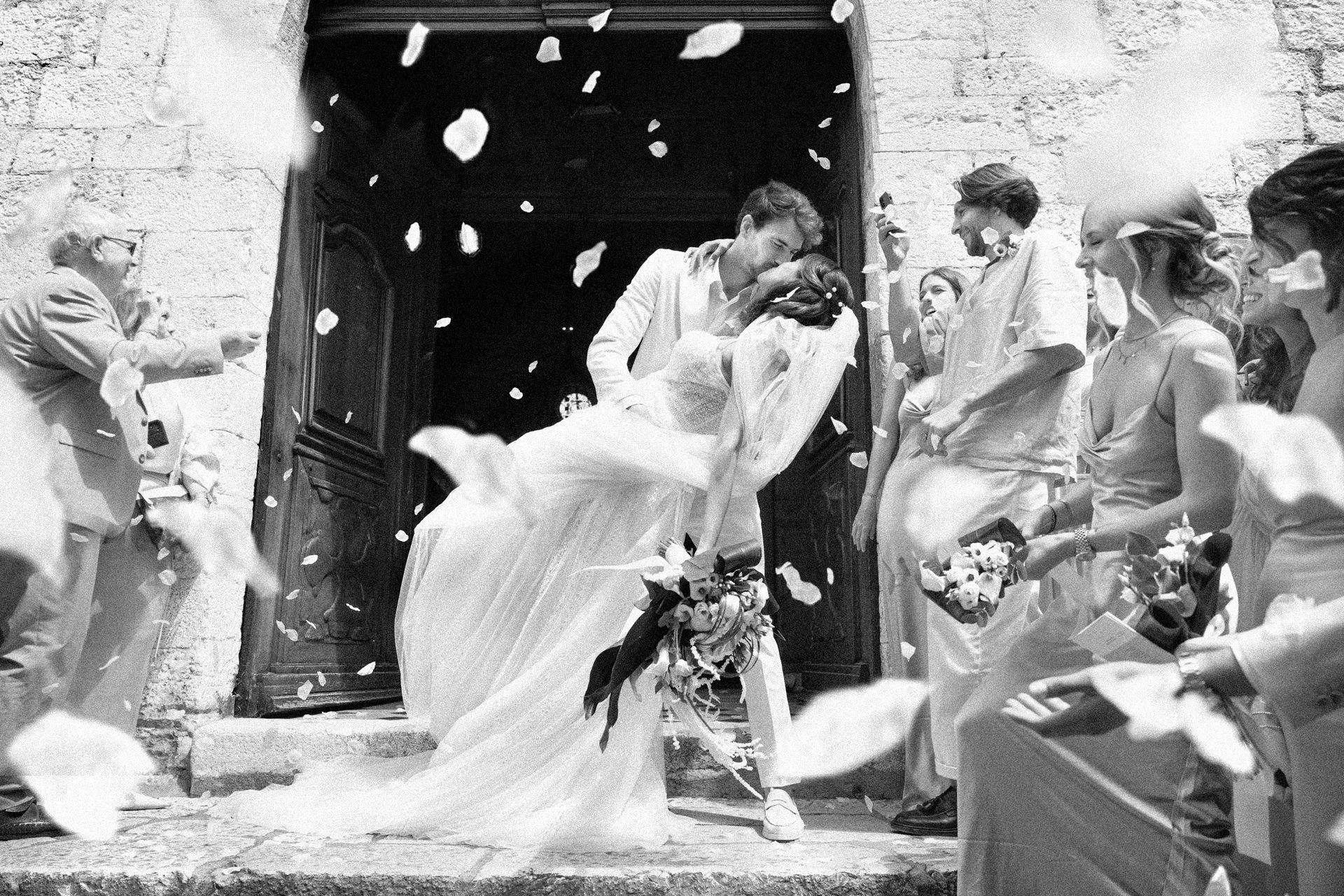 Photo de mariage professionnelle d'un lancer de confettis à l'extérieur de l'église de Saint-Paul-de-Vence