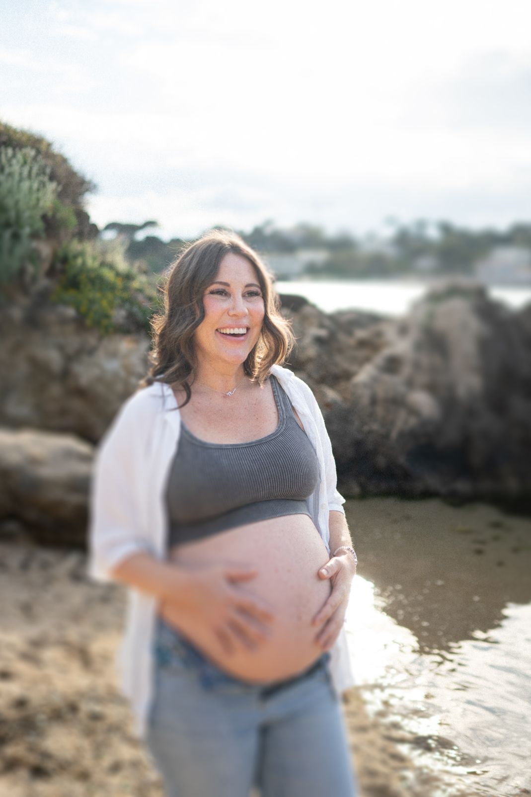 A pregnant woman laughing in an example of a maternity photoshoot on the French Riviera.