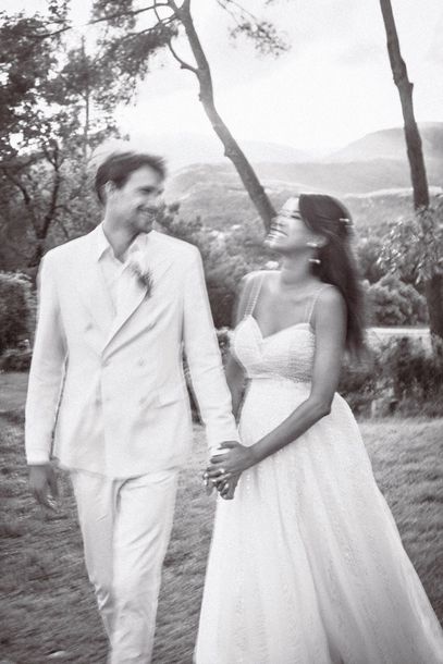 A couple in wedding attire during a photoshoot with motion blur in a grainy, camera film style photo.