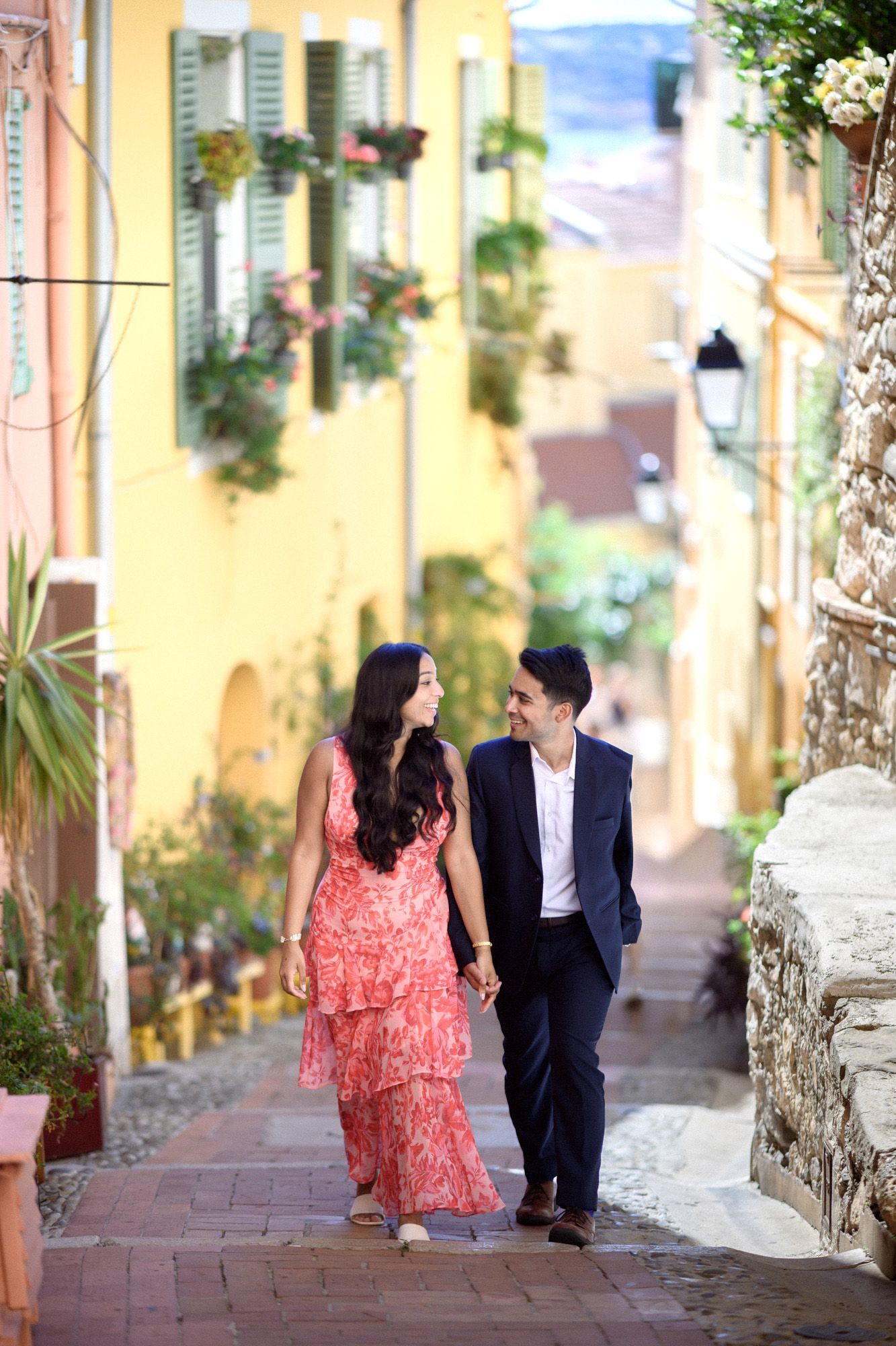 A natural, candid couple photoshoot in the streets of Menton with beautiful, old architecture in the background.