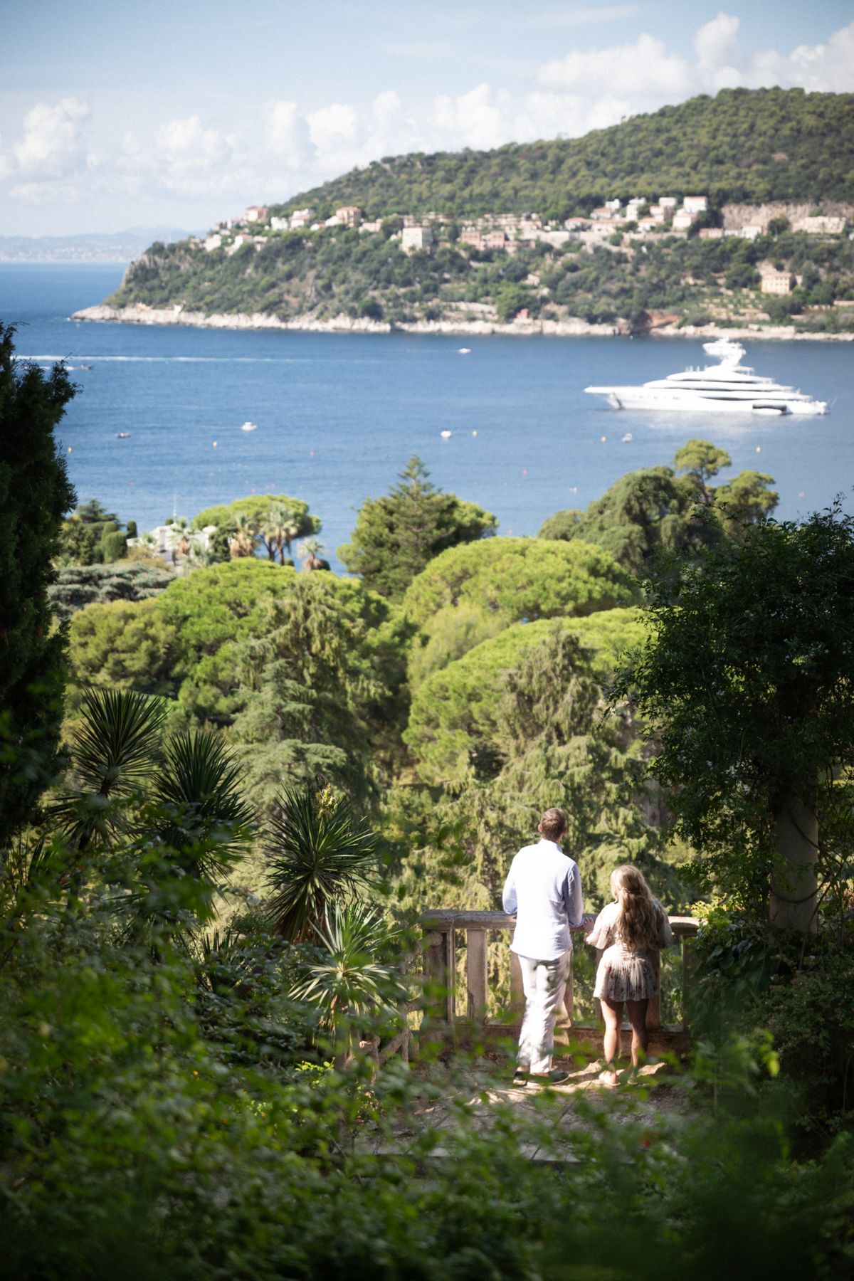 A wide angle image of a couple overlooking the sea from Villa Ephrussi's gardens.