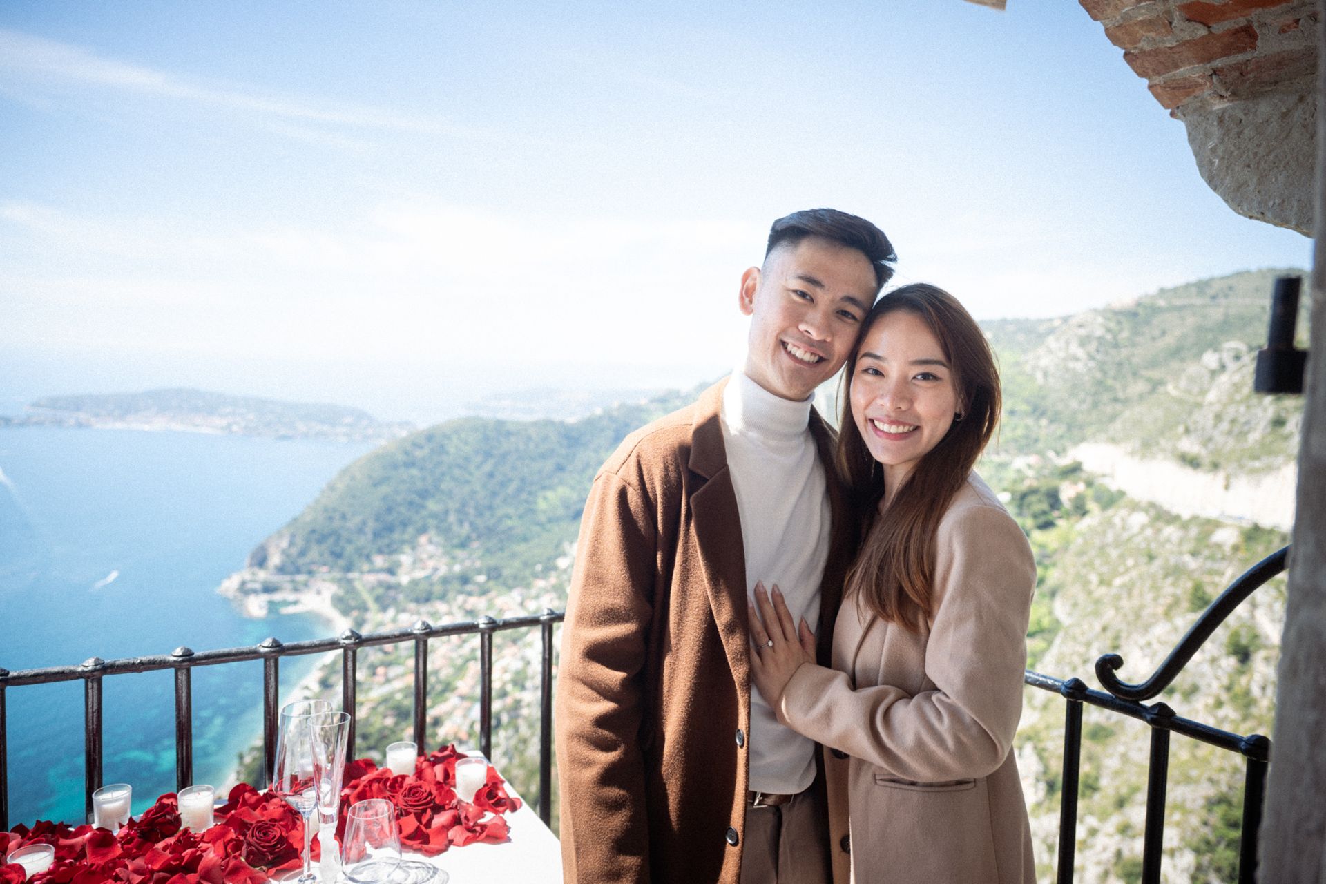 A couple smile after getting engaged on the French Riviera.