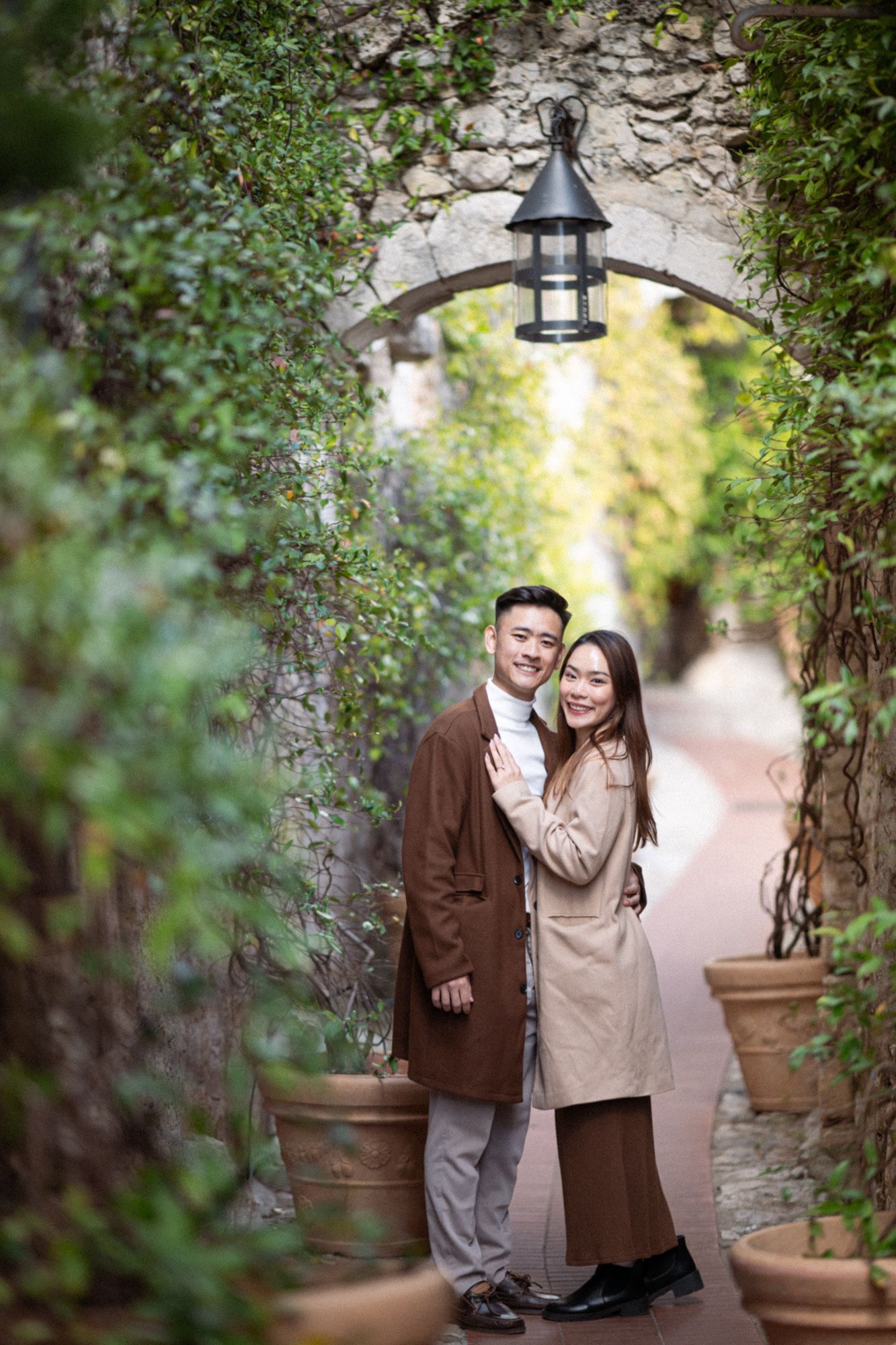 A professionally photographed romantic couple portrait in Eze village's archway.