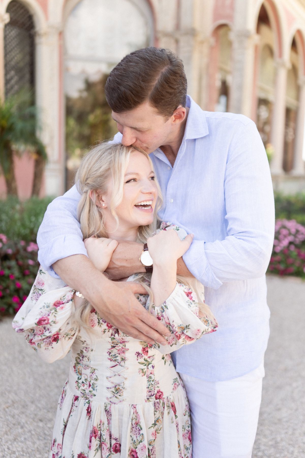 A couple hug and laugh during a photoshoot in the courtyard of Villa Ephrussi.