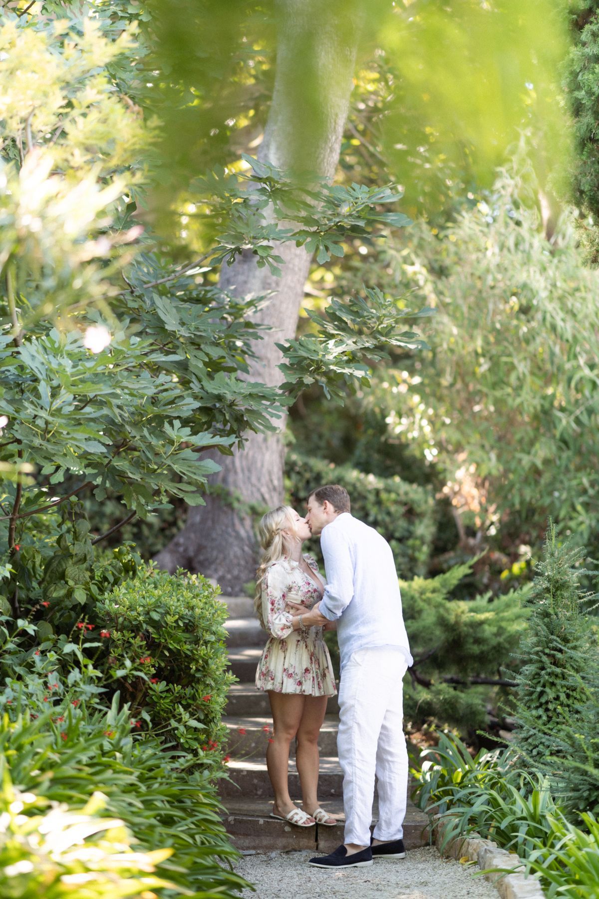 A couple embrace in the beautiful scenery of the Ephrussi gardens.