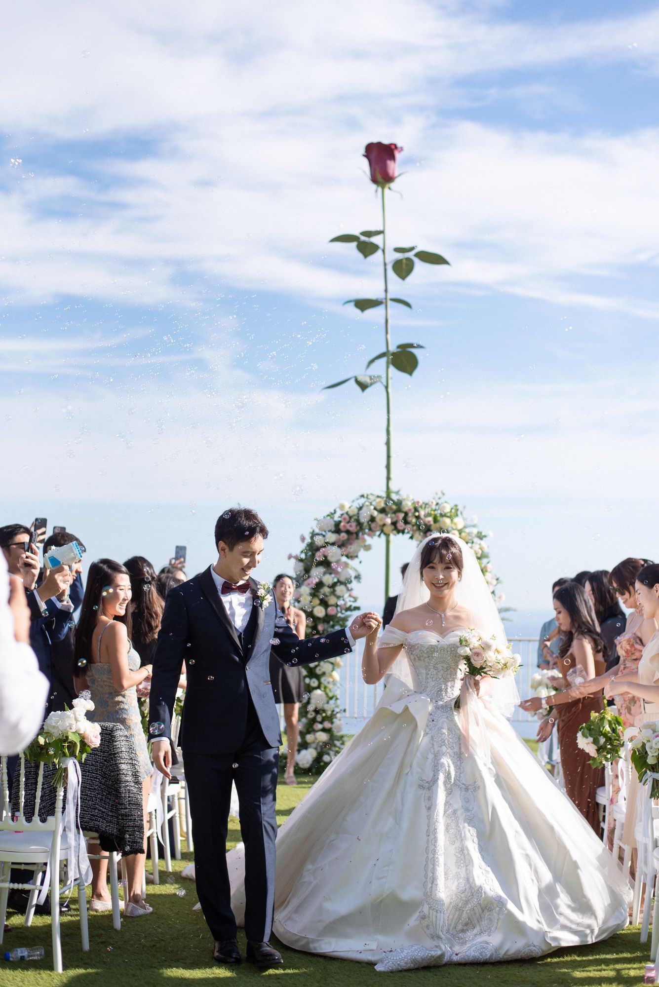 A couple walk through confetti at the end of their wedding ceremony at the Chevre d'Or Hotel