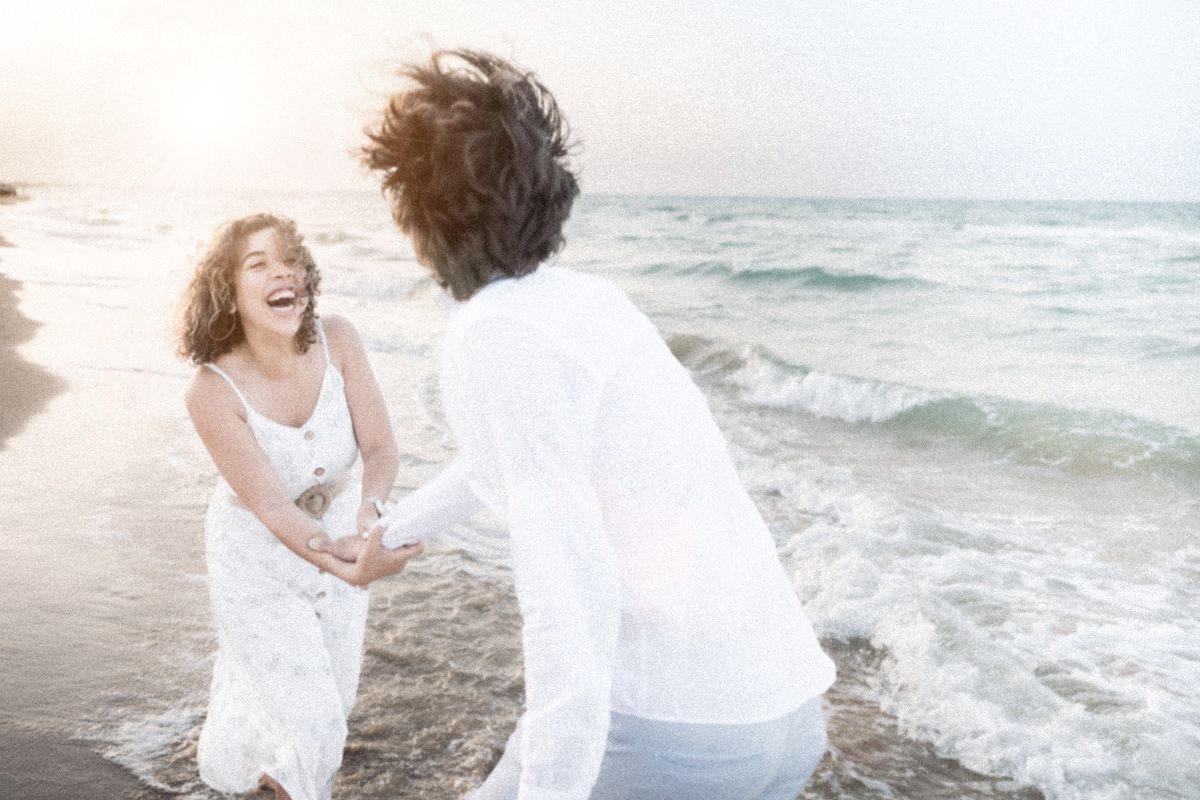 A talk and laugh as they are walking on the beach