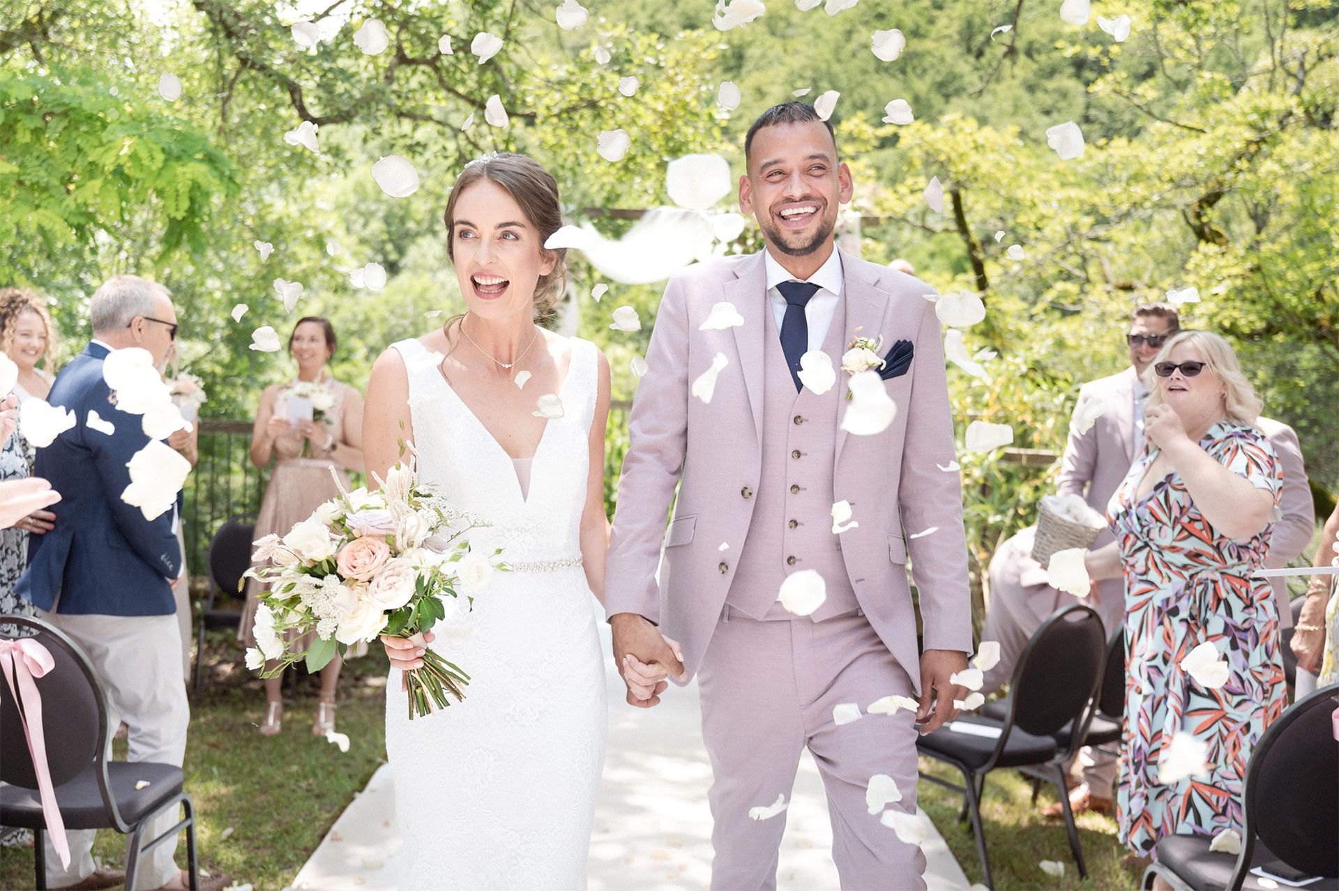 A couple wedded in the South of France are showered with confetti after their outdoor ceremony. 