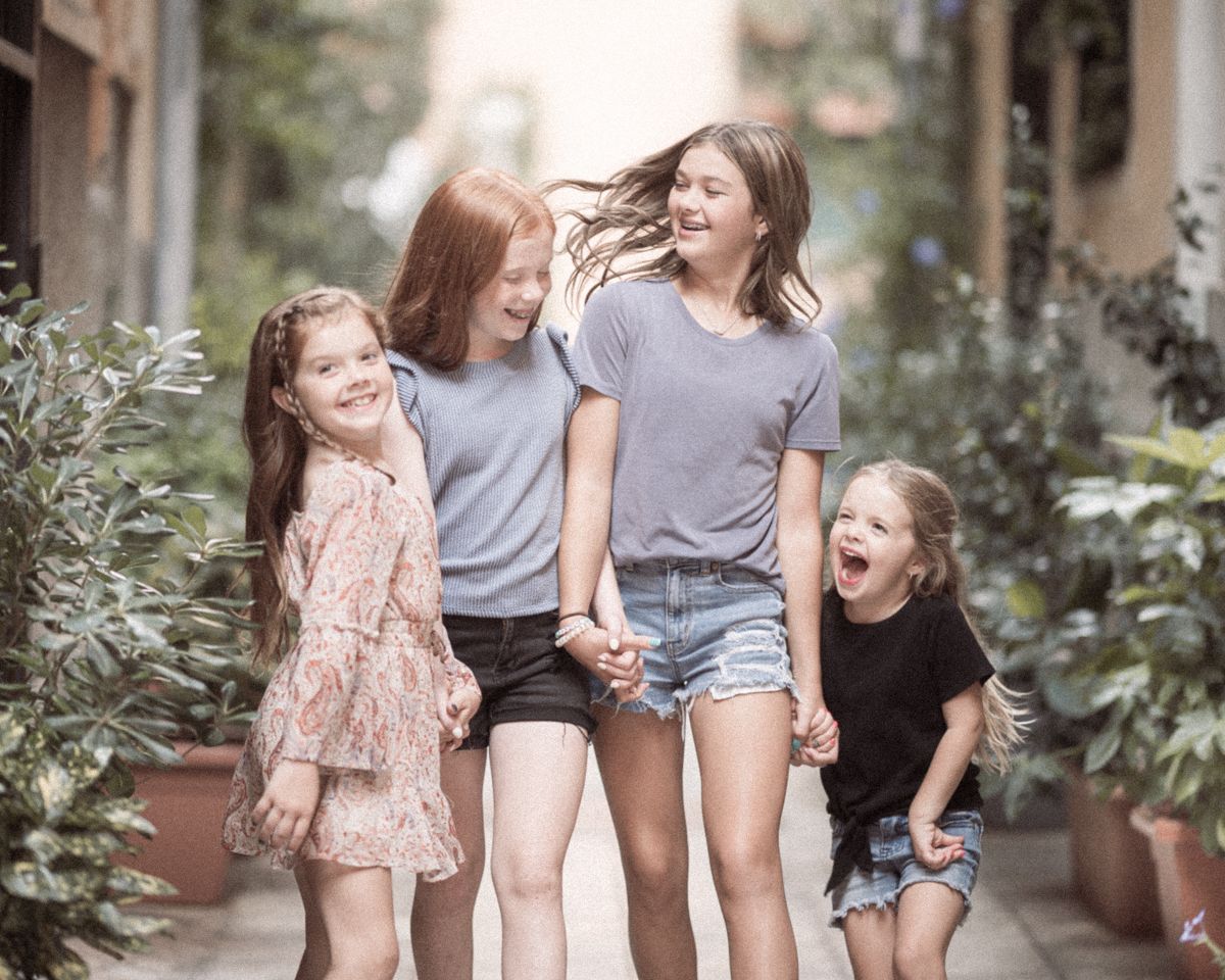 Four sisters laugh during a family photoshoot in Nice old town. Family photography by Peter Horton