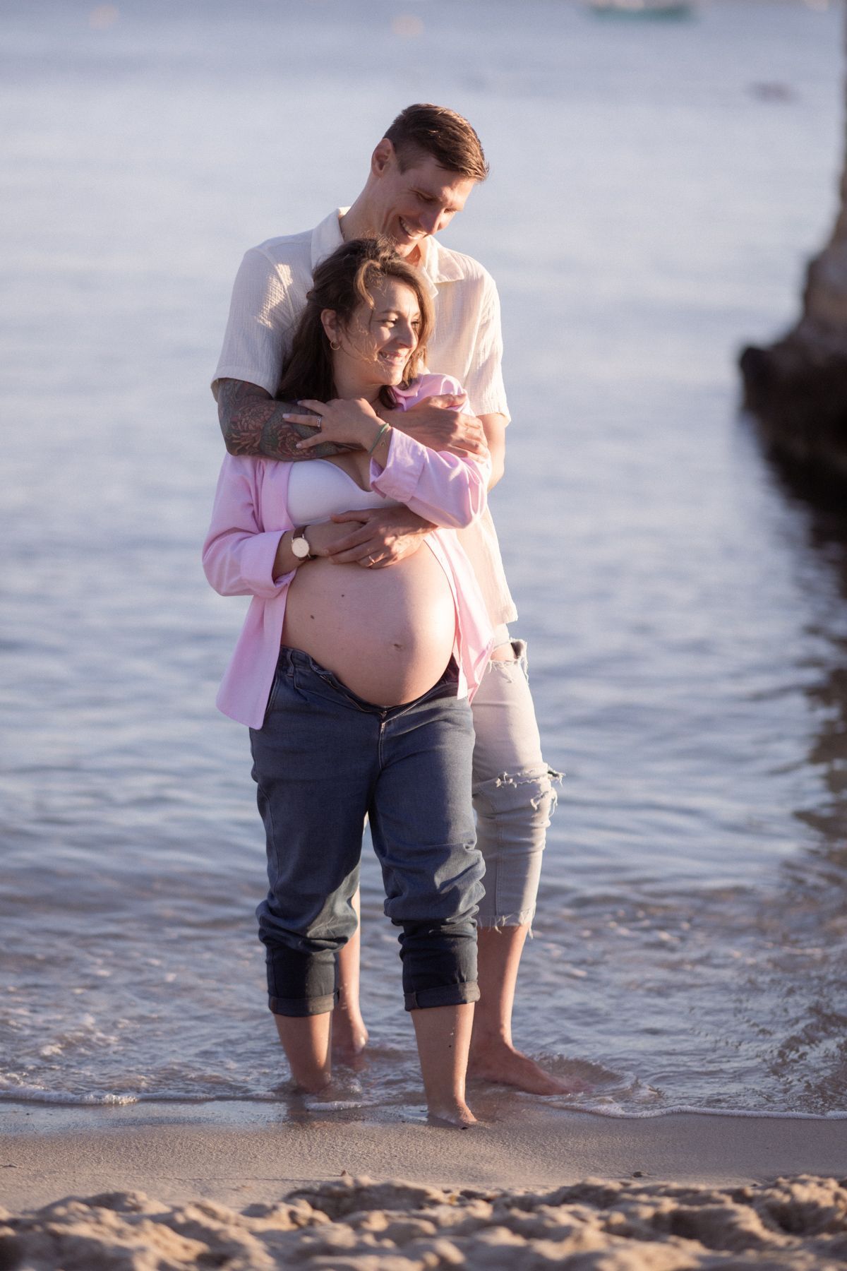 A couple in the sea during a maternity photoshoot at golden hour in Nice