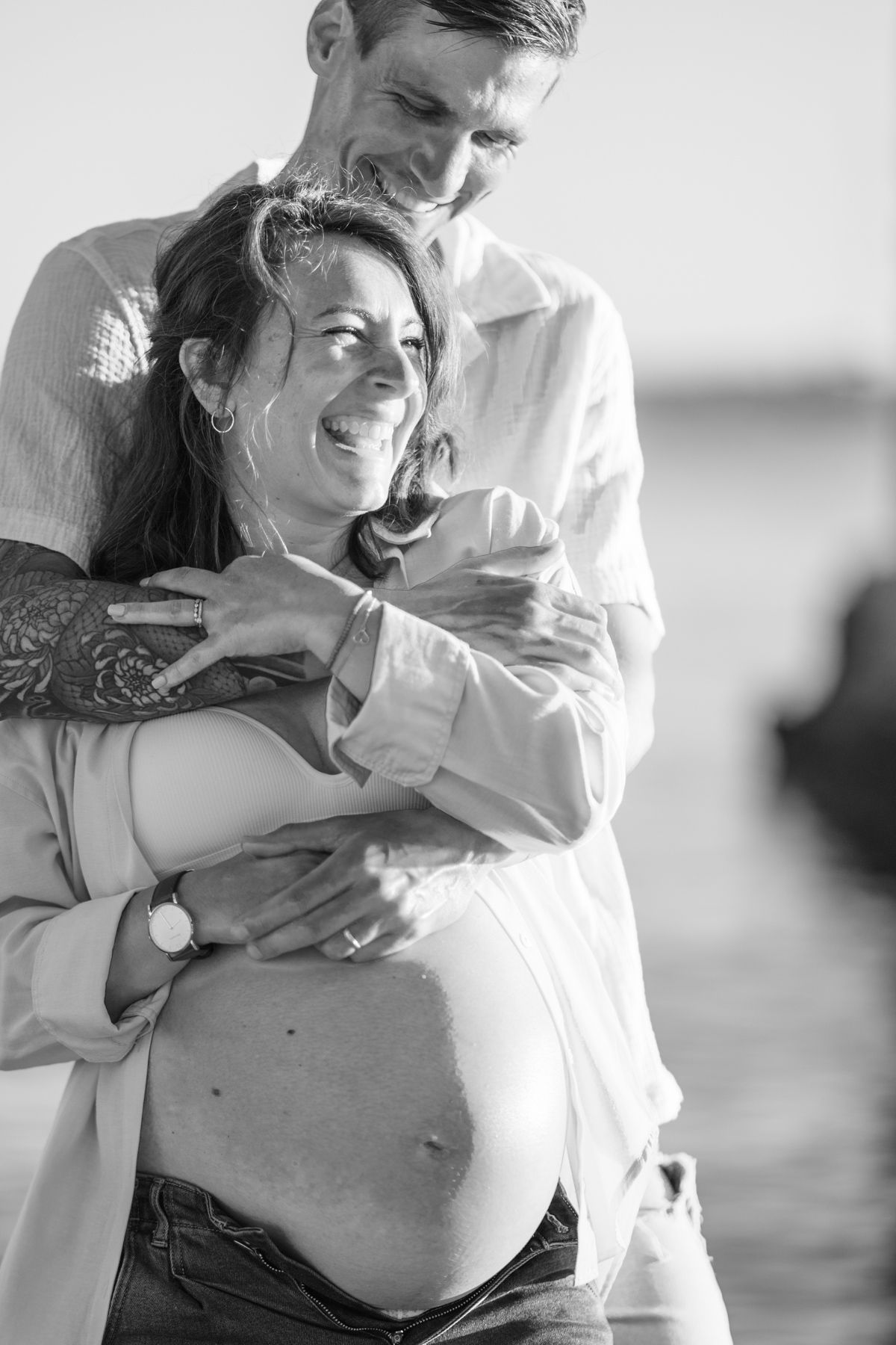 A monochrome image of a couple laughing during a maternity photoshoot in the south of France