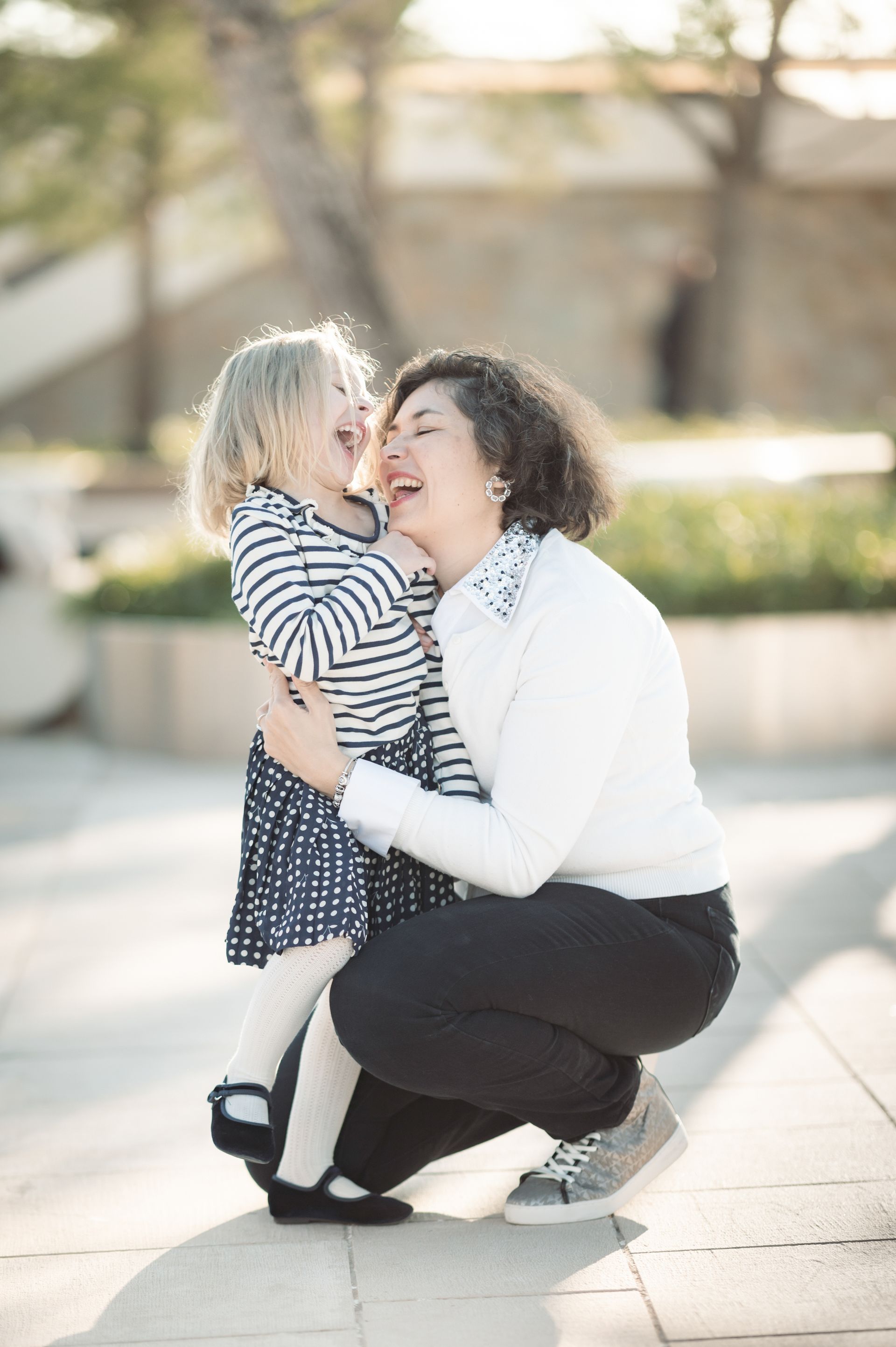 mother laughing with daughter during photo shoot
