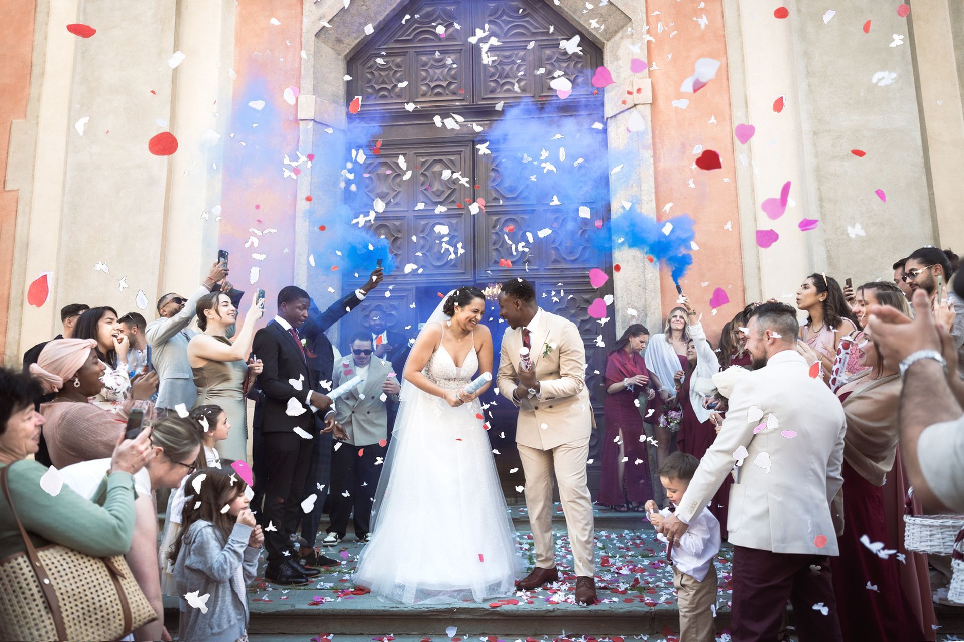 des confettis et des fusées éclairantes incroyables à l'extérieur d'une église après une cérémonie de mariage