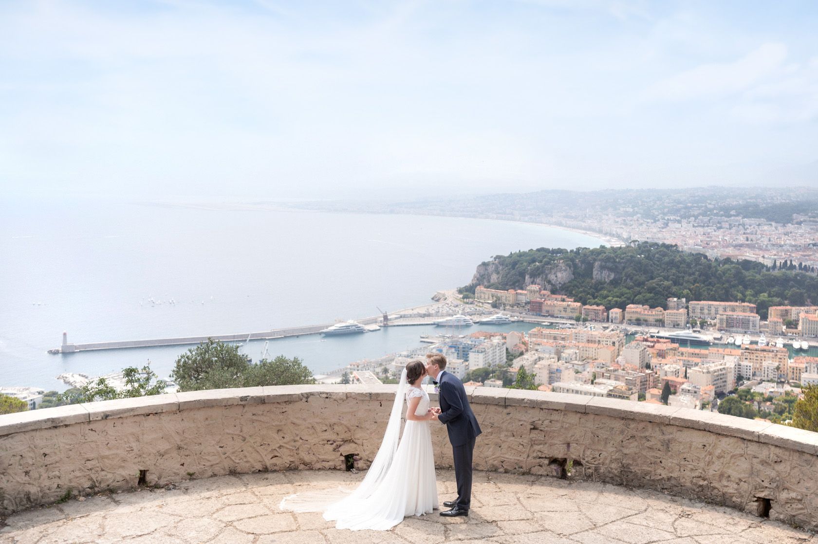 Un couple de mariés s'embrasse sur le Mont Boron en tenue de mariage