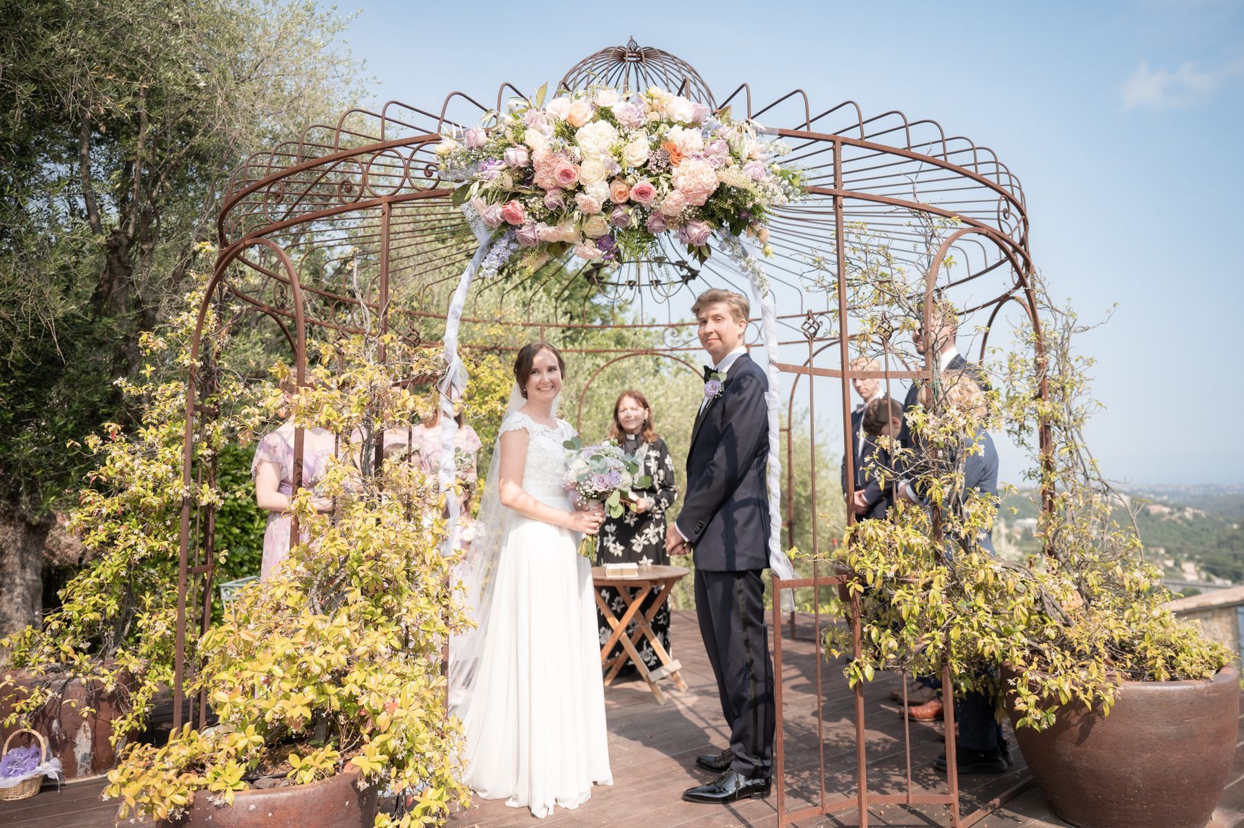 une cérémonie de mariage en plein air sous une véranda décorée de fleurs dans un verger