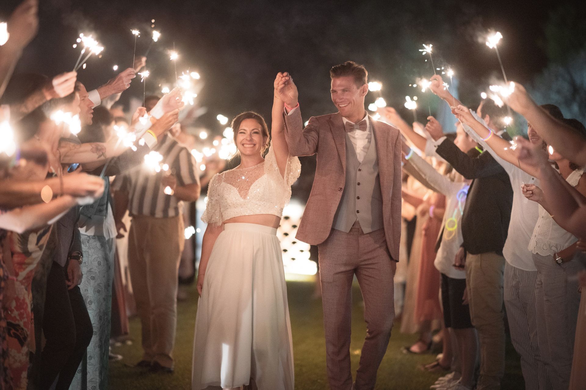 Un tunnel de cierges magiques lors d'un mariage de nuit.
