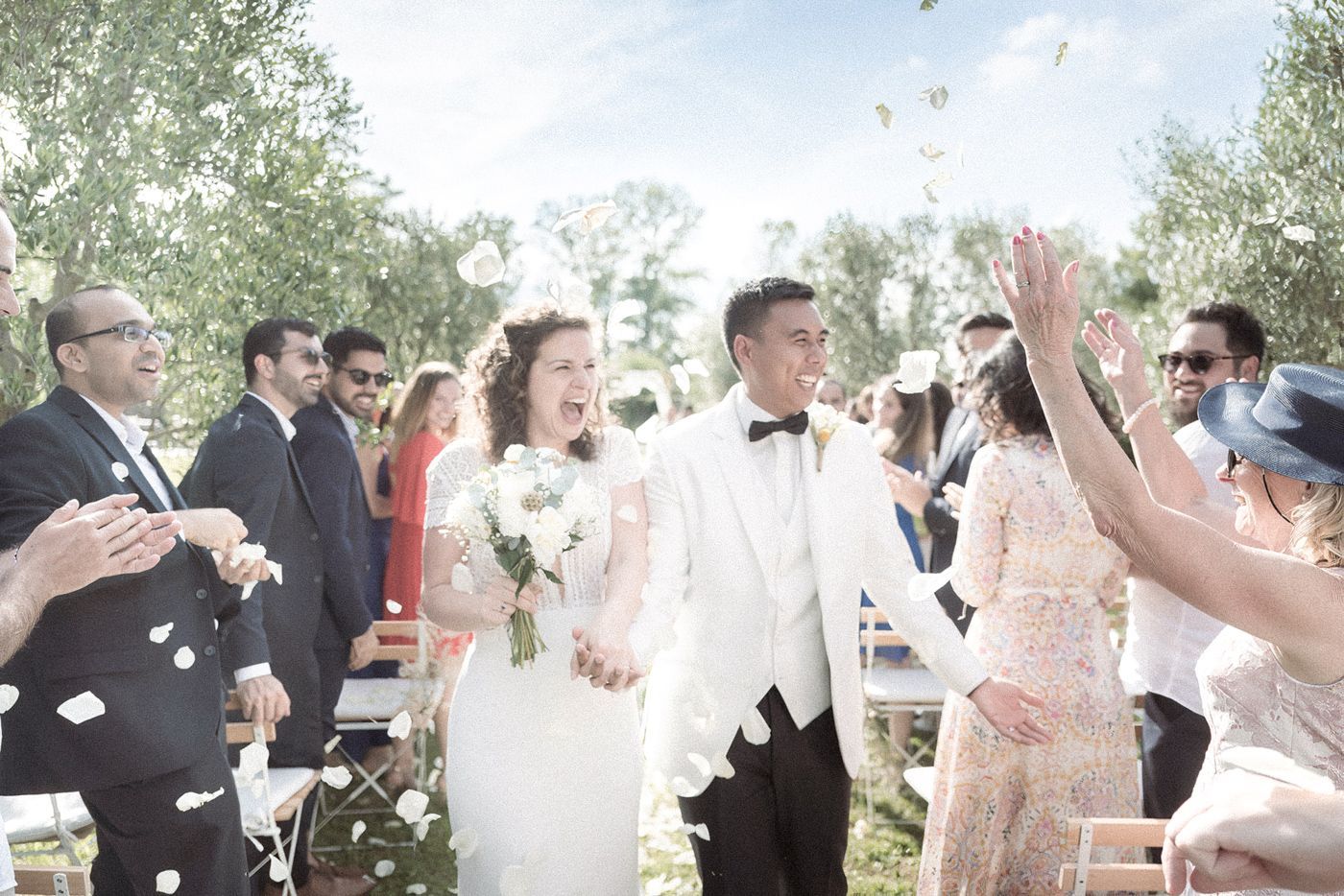 A couple walk through confetti after their wedding ceremony in Provence
